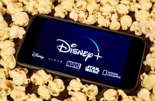 Celular com o aplicativo do Disney+ envolto de pipocas