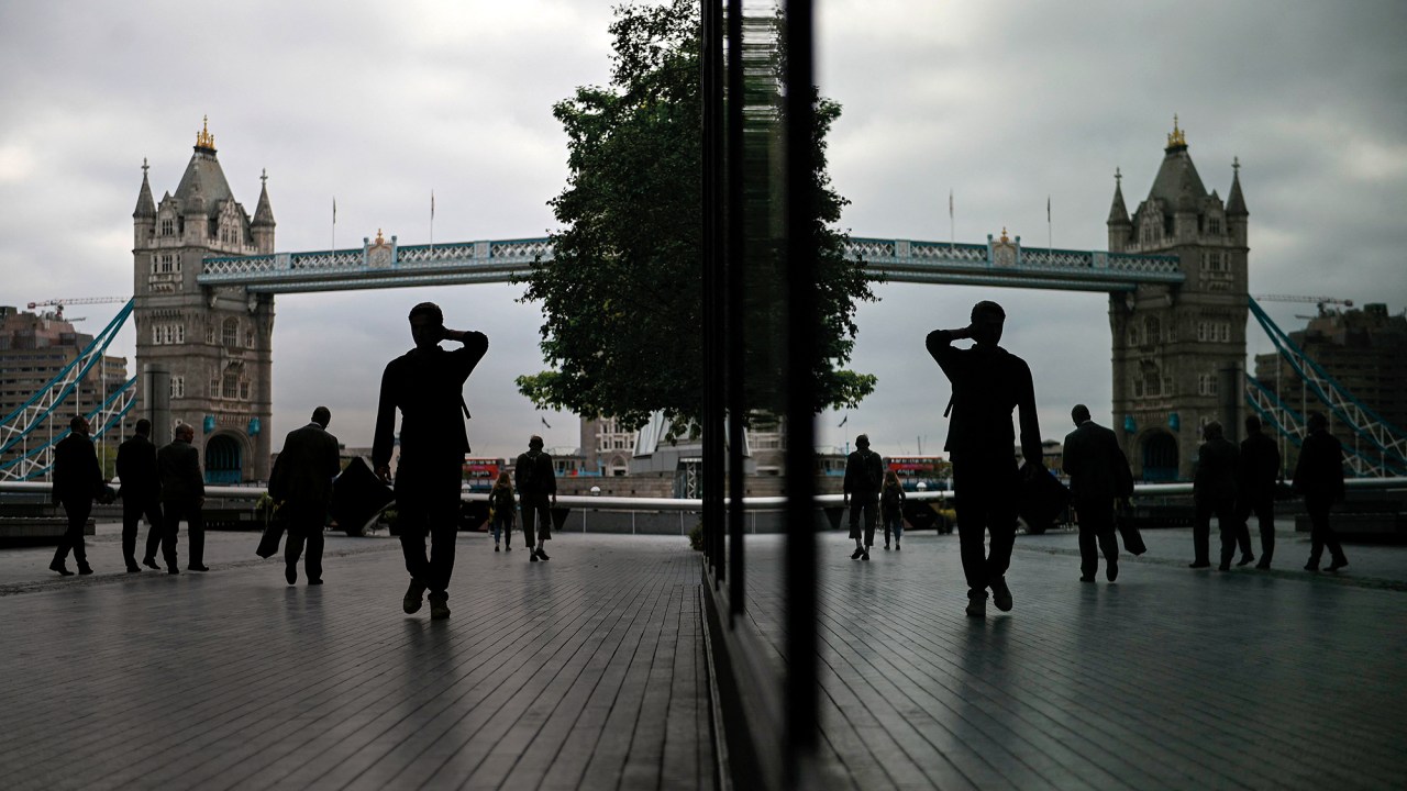 Pedestram caminham perto da Tower Bridge, em Londres