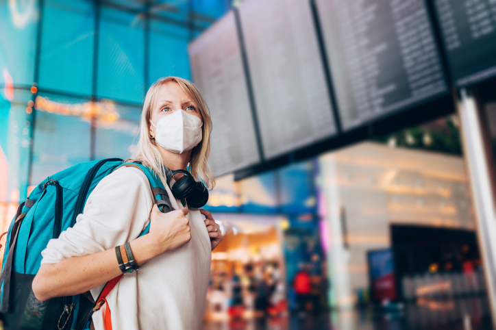 Passageira em aeroporto com máscara no rosto na pandemia (Getty Images)