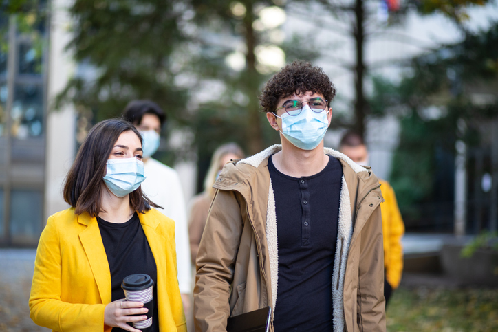 Pessoas com máscara no rosto ao ar livre (Getty Images)