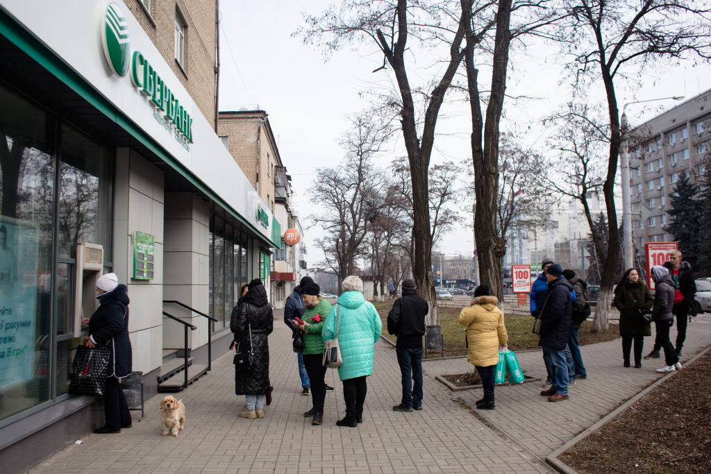 Pessoas esperam na fila de caixa eletrônico do Sberbank, o maior banco da Rússia, para sacar dinheiro em Kramatorsk, na Ucrânia, em 24 de fevereiro de 2022 (Foto de Anastasia Vlasova/Getty Images)