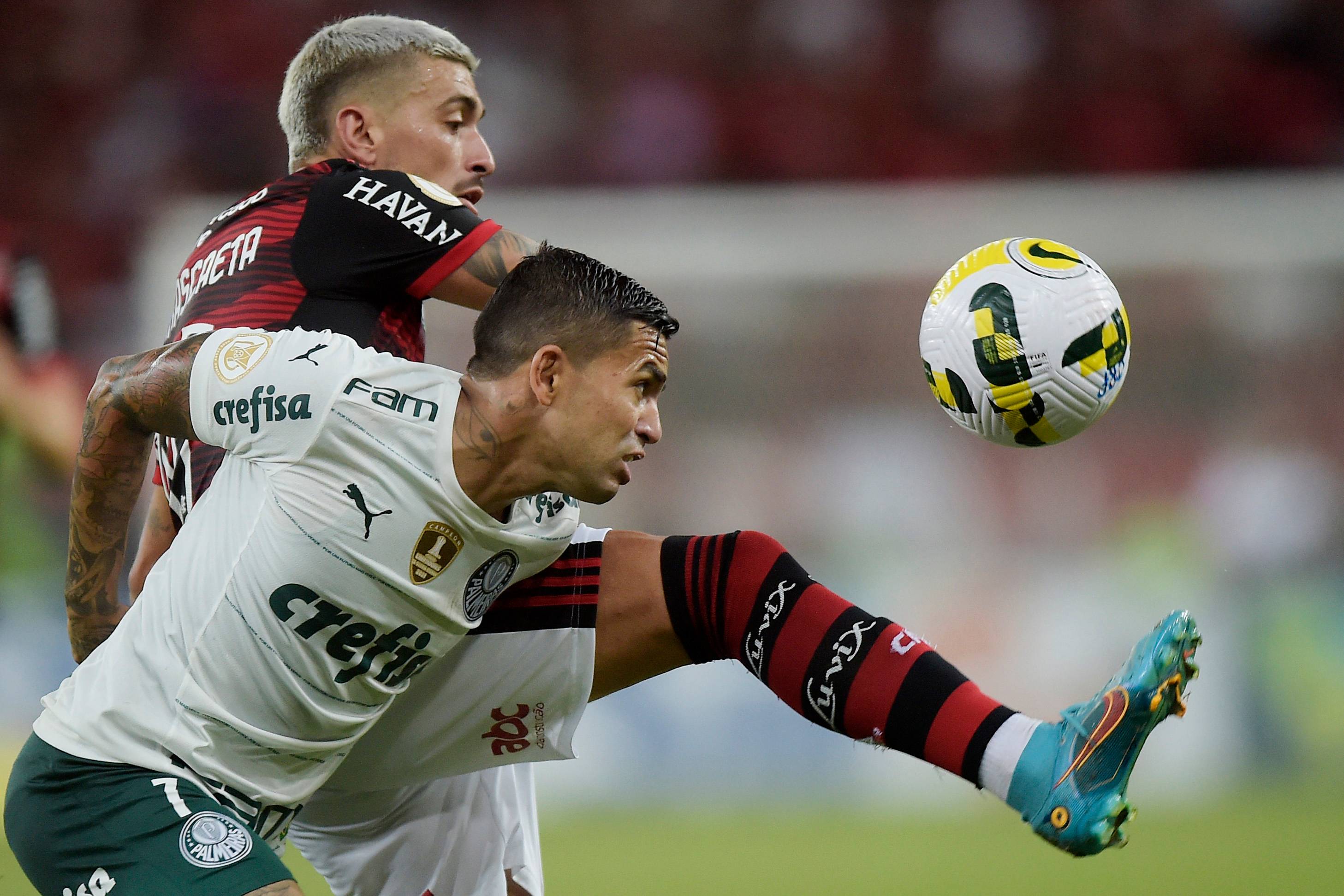 Dudu e de Arrascaeta disputam bola em jogo entre Flamengo e Palmeiras no Brasileiro de 2022; clubes foram campeões em arrecadação no futebol brasileiro em 2021 (Alexandre Loureiro/Getty Images)
