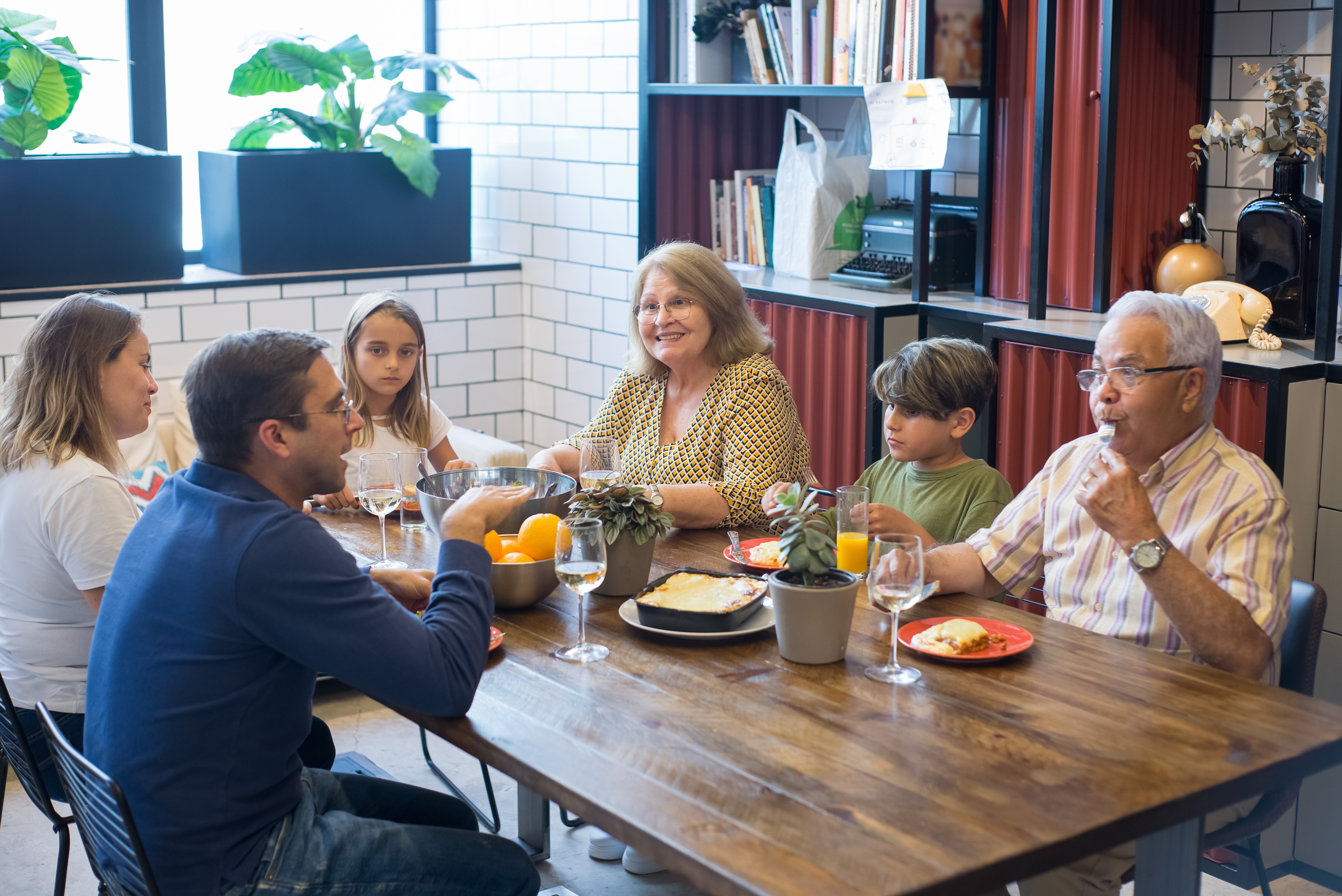 Familia de várias gerações conversando na mesa