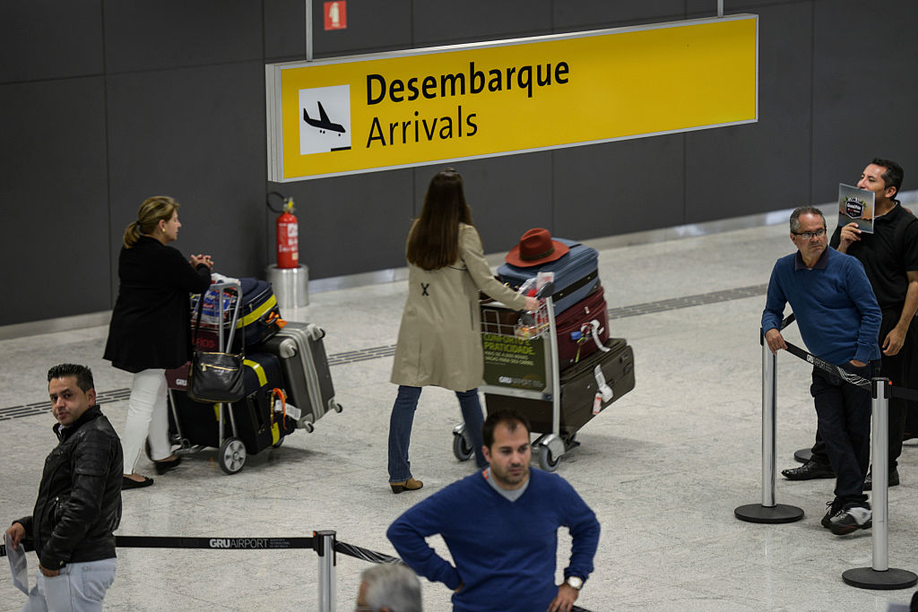 Passageiros que vieram dos EUA chegam ao Terminal 3 do Aeroporto Internacional de Guarulhos. no Brasil, em 22 de setembro de 2014 (Foto de Paulo Fridman/Corbis via Getty Images)