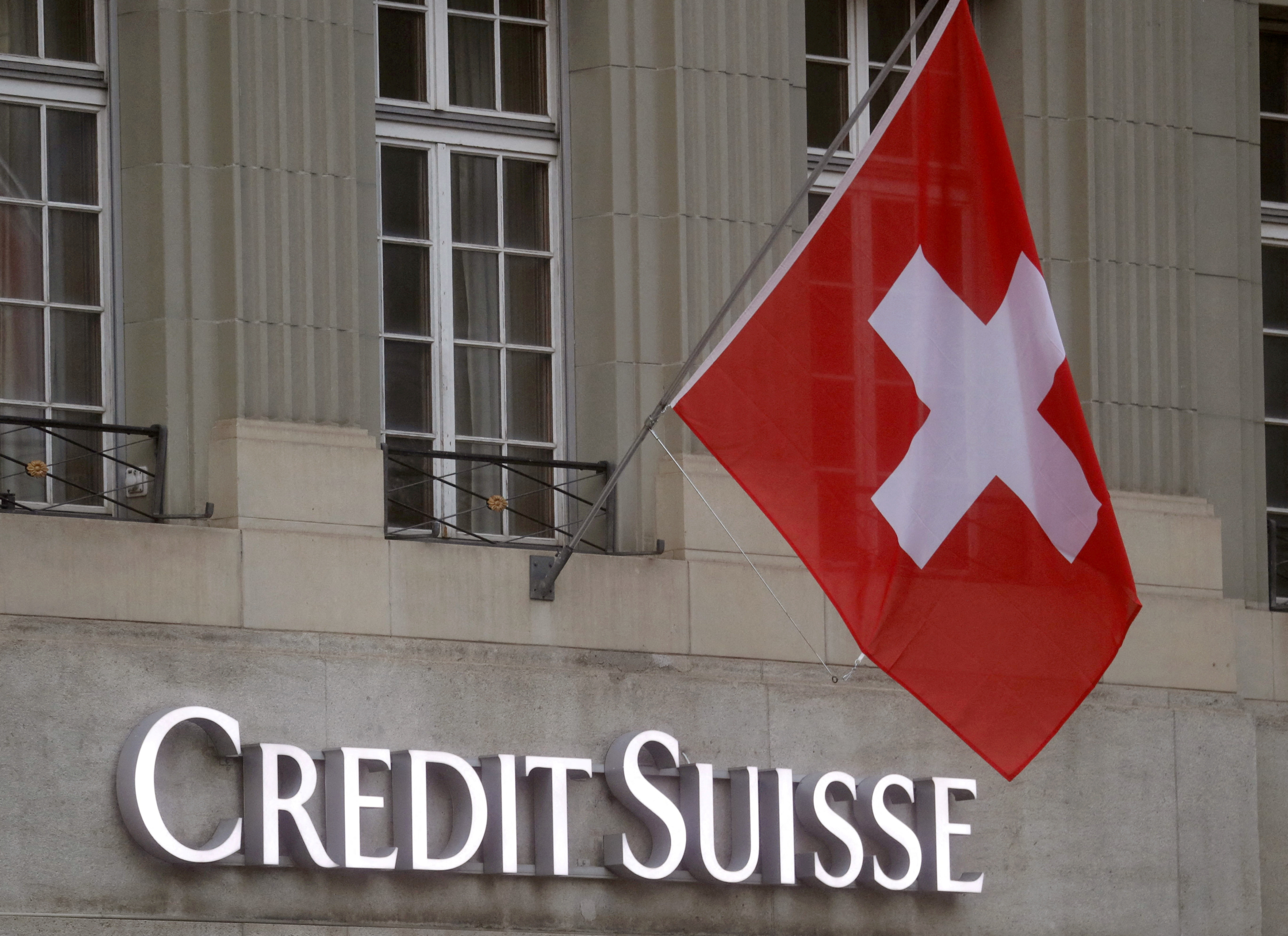 Bandeira nacional da Suíça tremula acima do logotipo do banco Credit Suisse em frente a uma filial em Berna, Suíça. 29/11/2022. REUTERS/Arnd Wiegmann