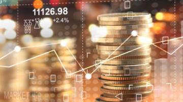Double explosure with businesss charts of graph and rows of coins for finance at night city background.