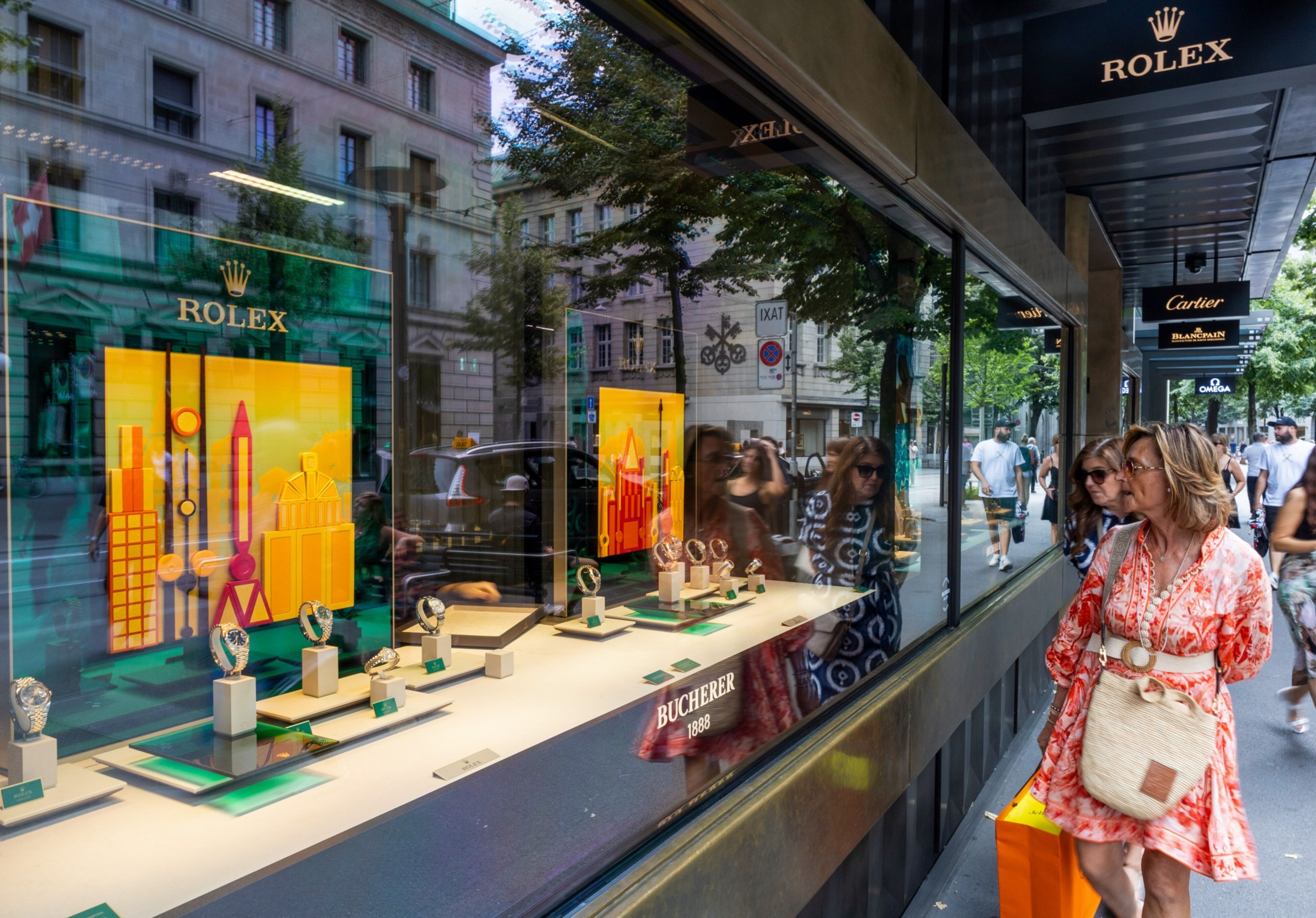 Shoppers browse a display of Rolex watches in the window of a Bucherer store in Zurich. (Foto: Bloomberg)