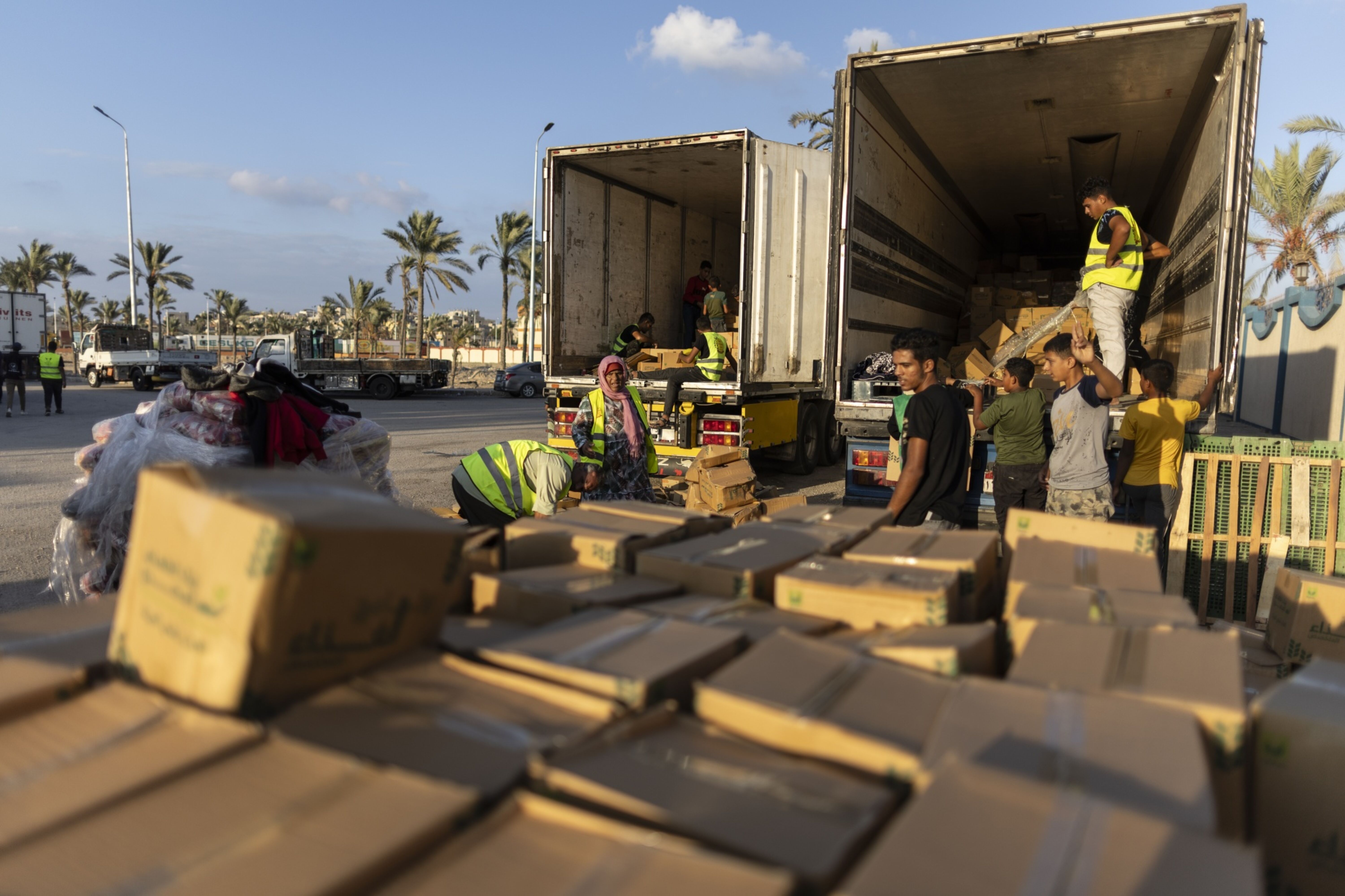 Voluntários carregam alimentos e suprimentos em caminhões em um comboio de ajuda humanitária em 16 de outubro no Sinai do Norte, Egito (Bloomberg)