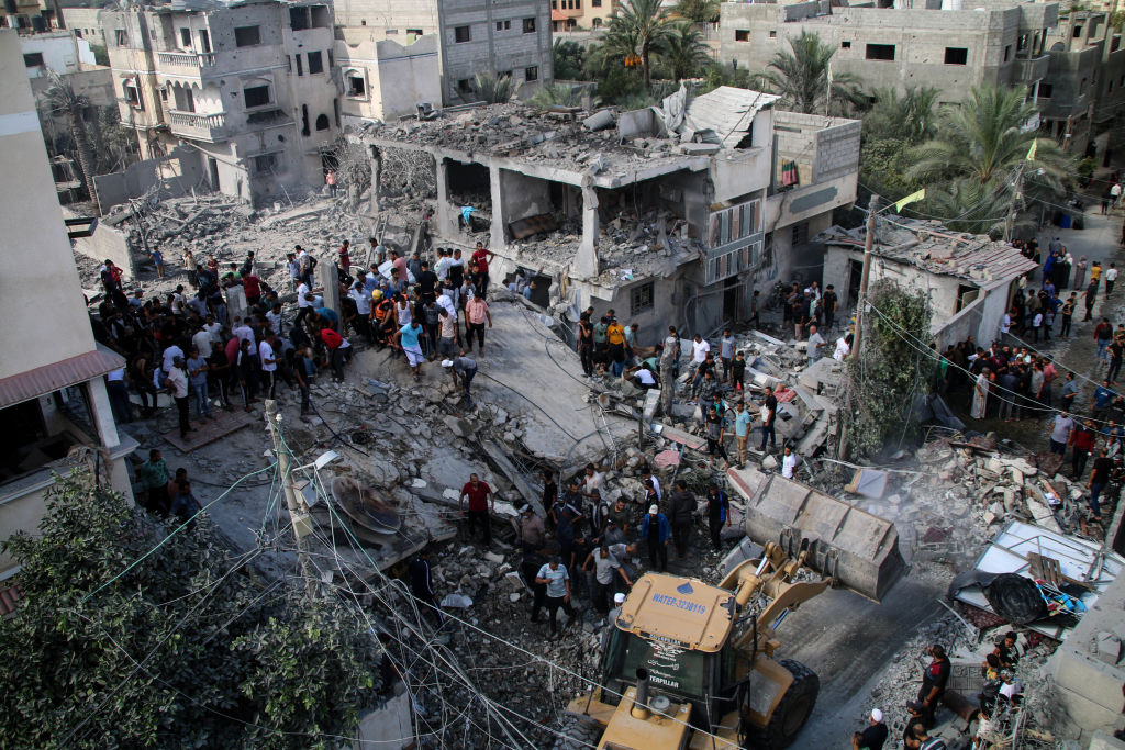 KHAN YOUNIS, GAZA - OCTOBER 18: Palestinian emergency services and local citizens search for victims in buildings destroyed during Israeli air raids in the southern Gaza Strip on October 18, 2023 in Khan Yunis, Gaza. Gazans are evacuating to the south as advised by the Israeli government, ahead of an expected Israeli ground offensive. Israel has sealed off Gaza, leaving the entire population without fuel, water or aid, and launched sustained retaliatory air strikes, which have killed more than 2,000 people and some 400,000 displaced, after a large-scale attack by Hamas. On October 7, the Palestinian militant group Hamas launched a surprise attack on Israel from Gaza by land, sea, and air, killing over 1,300 people and wounding around 2,800. Israeli soldiers and civilians have also been taken hostage by Hamas and moved into Gaza. The attack prompted a declaration of war by Israeli Prime Minister Benjamin Netanyahu and the announcement of an emergency wartime government. (Photo by Ahmad Hasaballah/Getty Images)