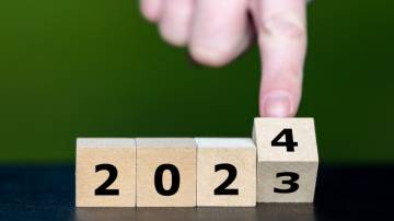Foto de stock de Mão vira cubo e muda do ano de 2023 para o ano de 2024.