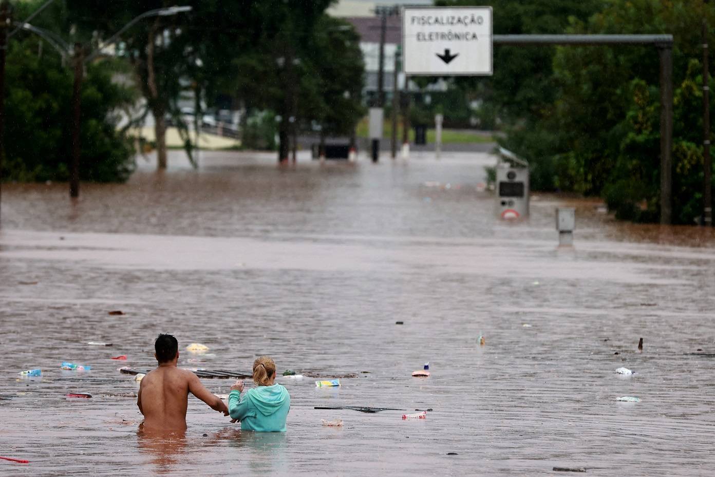 Pessoas tentam passar por área alagada em Encantado, no Rio Grande do Sul (REUTERS/Diego Vara)
