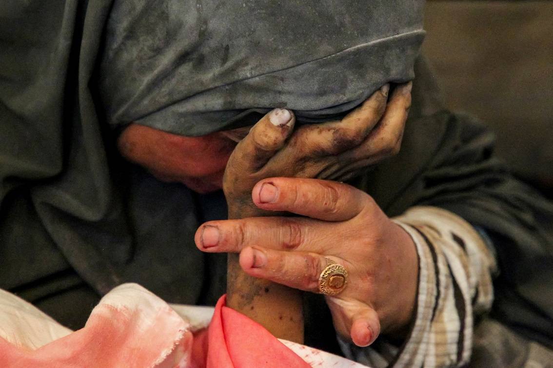 Mulher palestina segura a mão de seu filho Hazma, morto em um ataque israelense em Rafah, no sul da Faixa de Gaza.
09/05/2024
REUTERS/Hatem Khaled