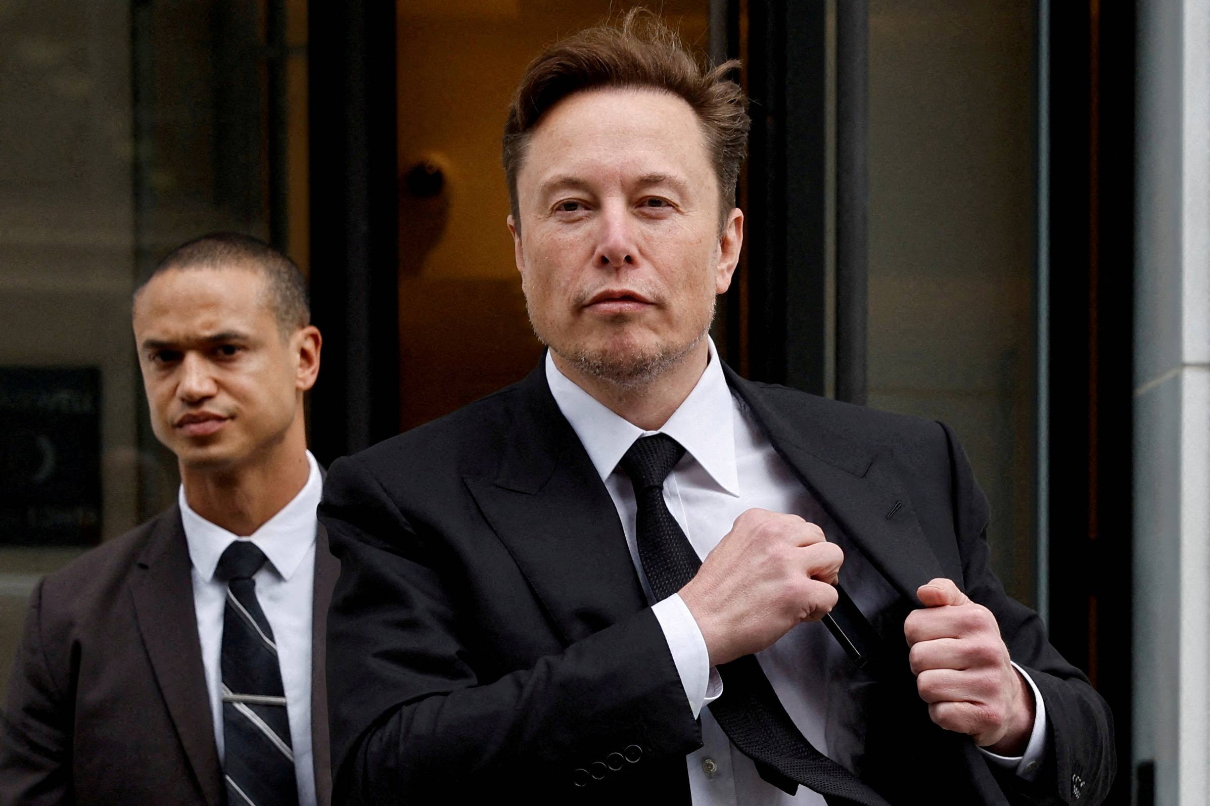 Elon Musk deixa escritório da Tesla em Washington acompanhado de segurança (REUTERS/Jonathan Ernst)