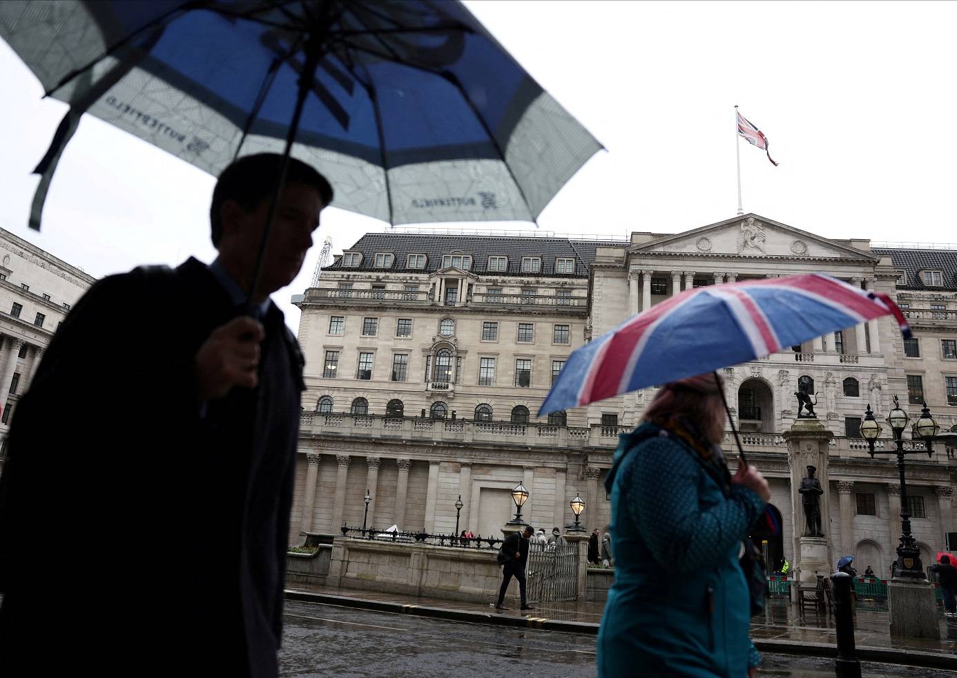 Turista se protege da chuva perto do Banco da Inglaterra, em Londres (Foto: Isabel Infantes/Reuters)