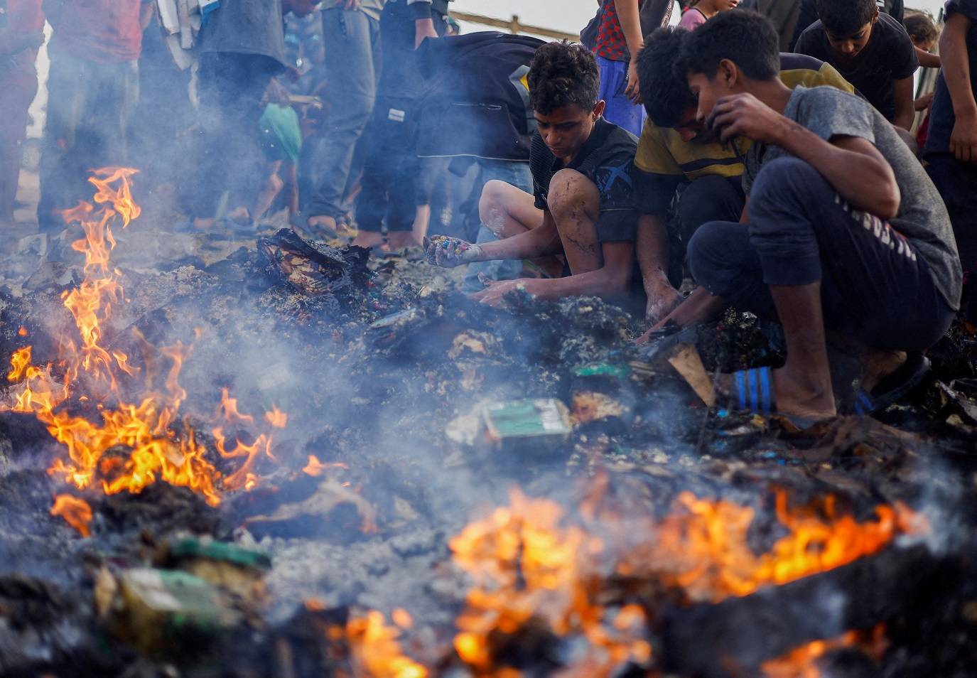 Palestino procura por comida após ataque israelense em local designado para pessoas desalojadas em Rafah, no sul da Faixa de Gaza (REUTERS/Mohammed Salem)