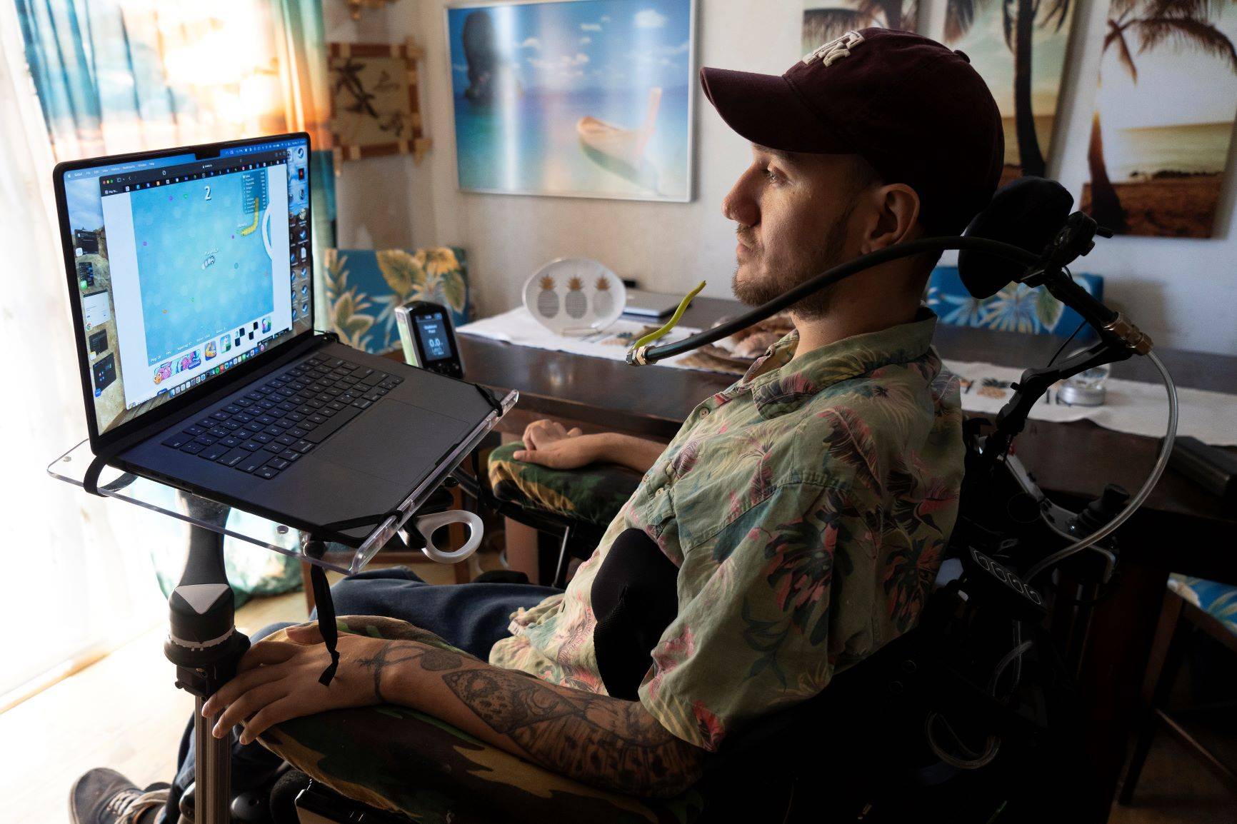 Noland Arbaugh, o primeiro paciente a participar do ensaio clínico em humanos testando o dispositivo Neuralink de Elon Musk, que está paralisado da quarta vértebra do pescoço para baixo devido a um acidente, interpreta Snake com a ajuda do implante Neuralink em sua casa em Yuma, Arizona, 21 de maio de 2024. (Rebecca Noble/The New York Times)