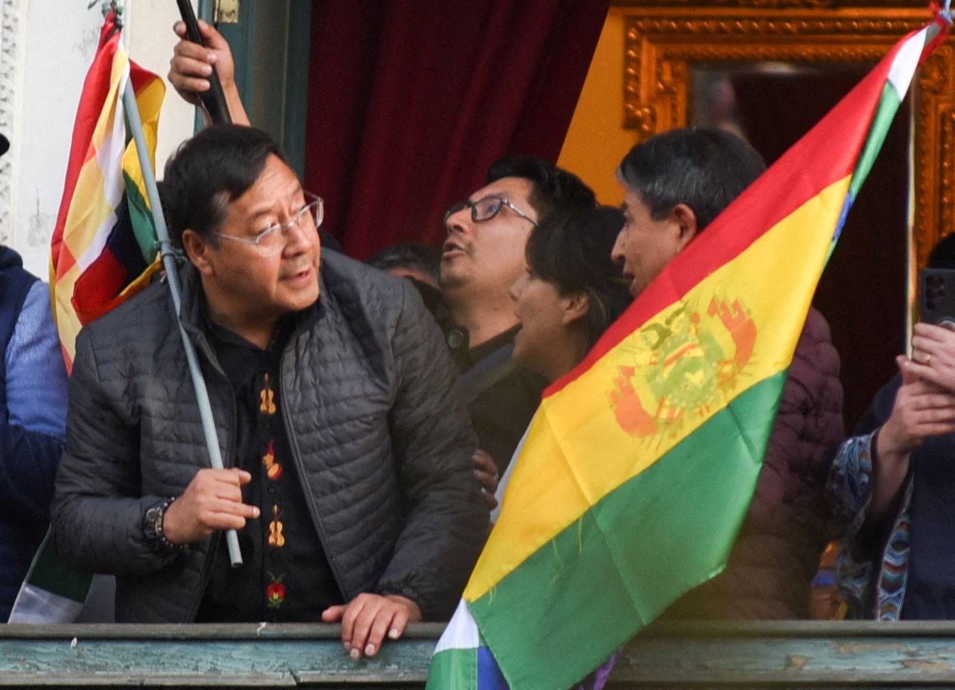 O presidente da Bolívia, Luis Arce, segura uma bandeira em uma varanda após “denunciar a mobilização irregular” de algumas unidades do exército do país em La Paz, Bolívia, 26 de junho de 2024. REUTERS/Claudia Morales TPX IMAGENS DO DIA