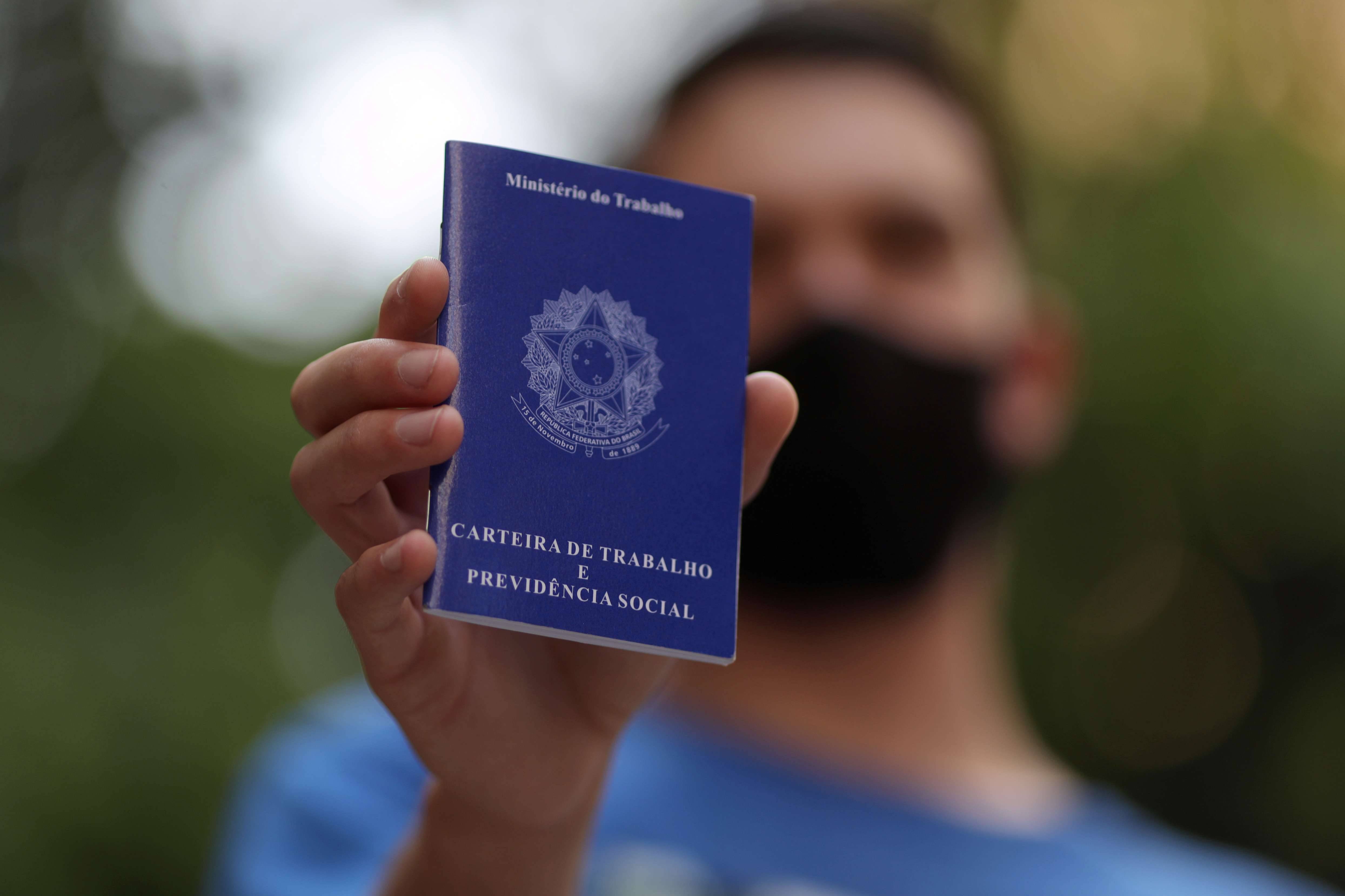 Homem segura carteira de trabalho em São Paulo  (Foto: Amanda Perobelli/Reuters)