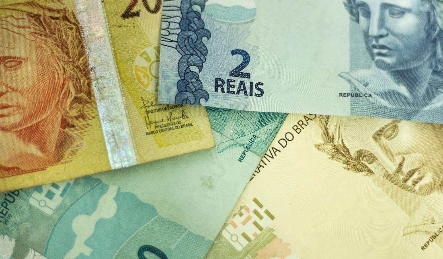 Notas de real sobrepostas (Foto: Daniel Dan/Pexels)