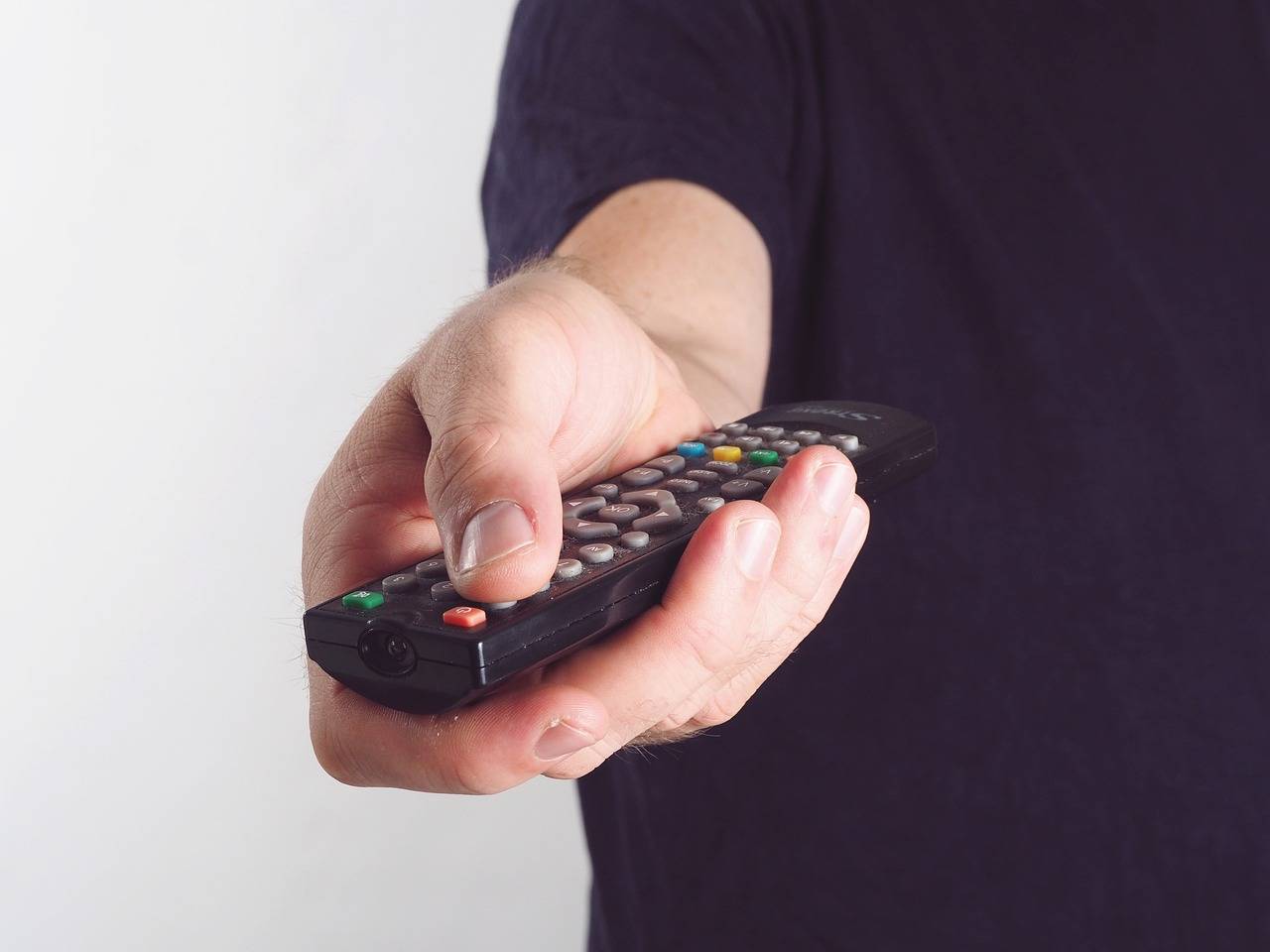 mão segurando controle de TV