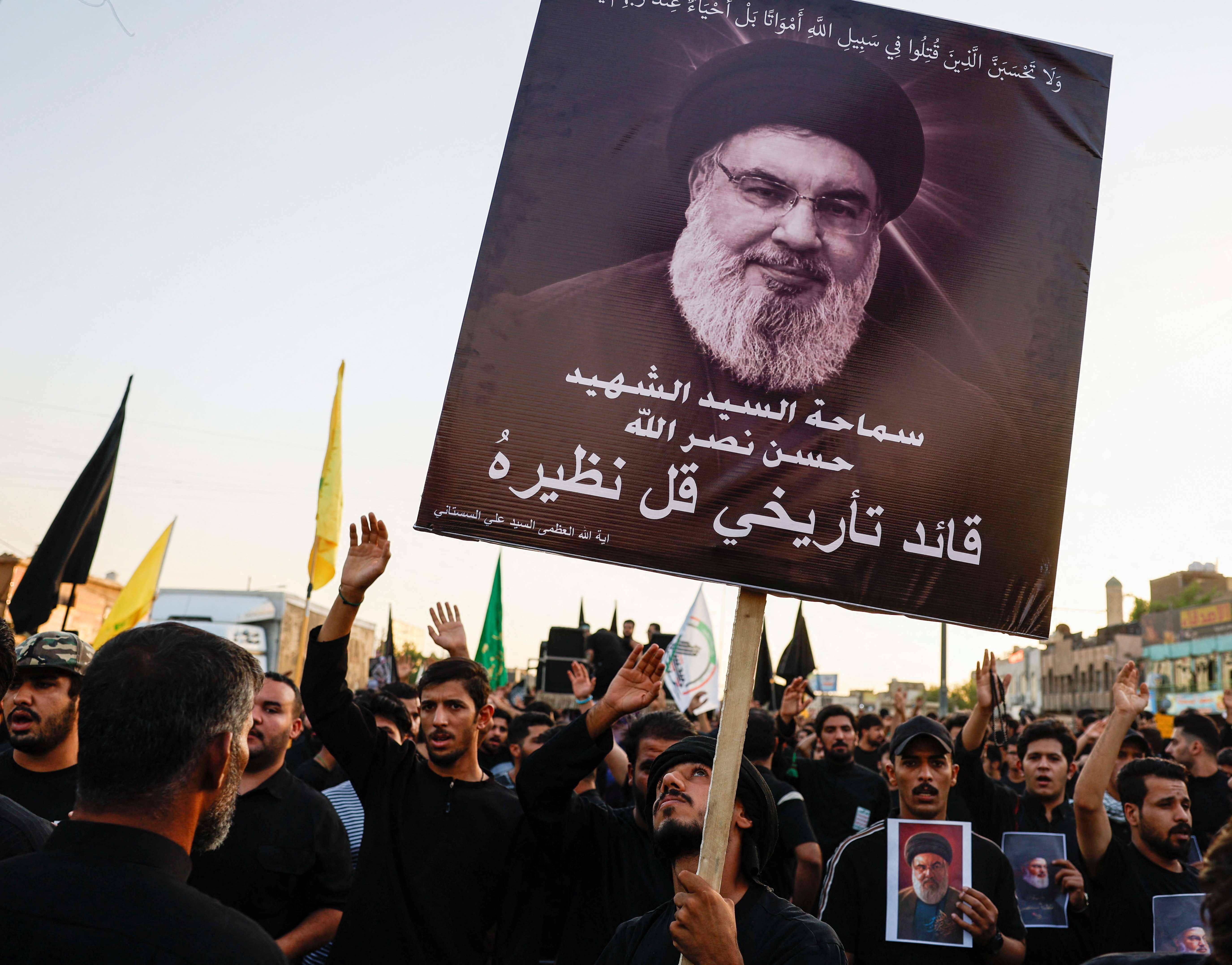 Uma pessoa segura cartaz do chefe do Hezbollah, Hassan Nasrallah, morto num ataque aéreo israelense (Foto: Thaier al-Sudani/Reuters)