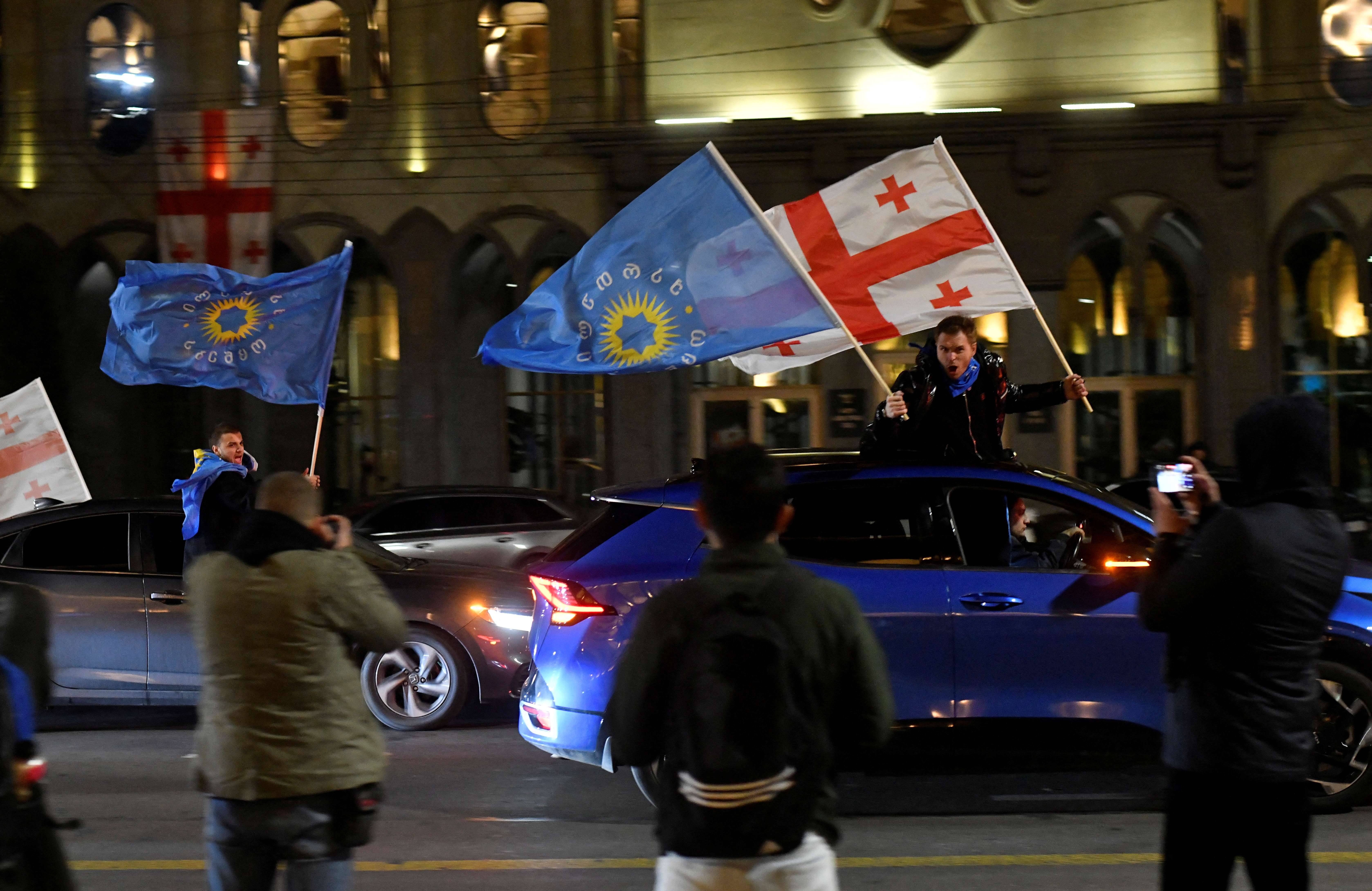 Apoiadores do partido Sonho Georgiano comemoram após anúncio de pesquisas de boca de urna em Tbilisi - 26/10/2024 (Foto: Zurab Javakhadze/Reuters)