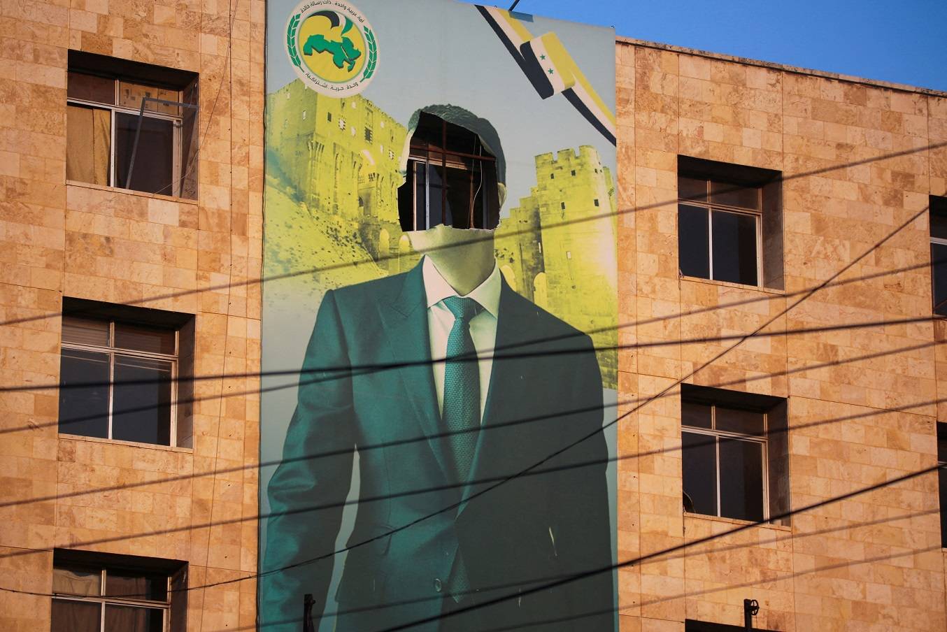 Cartaz danificado do presidente da Síria, Bashar al-Assad, em Aleppo (REUTERS/Mahmoud Hassano)