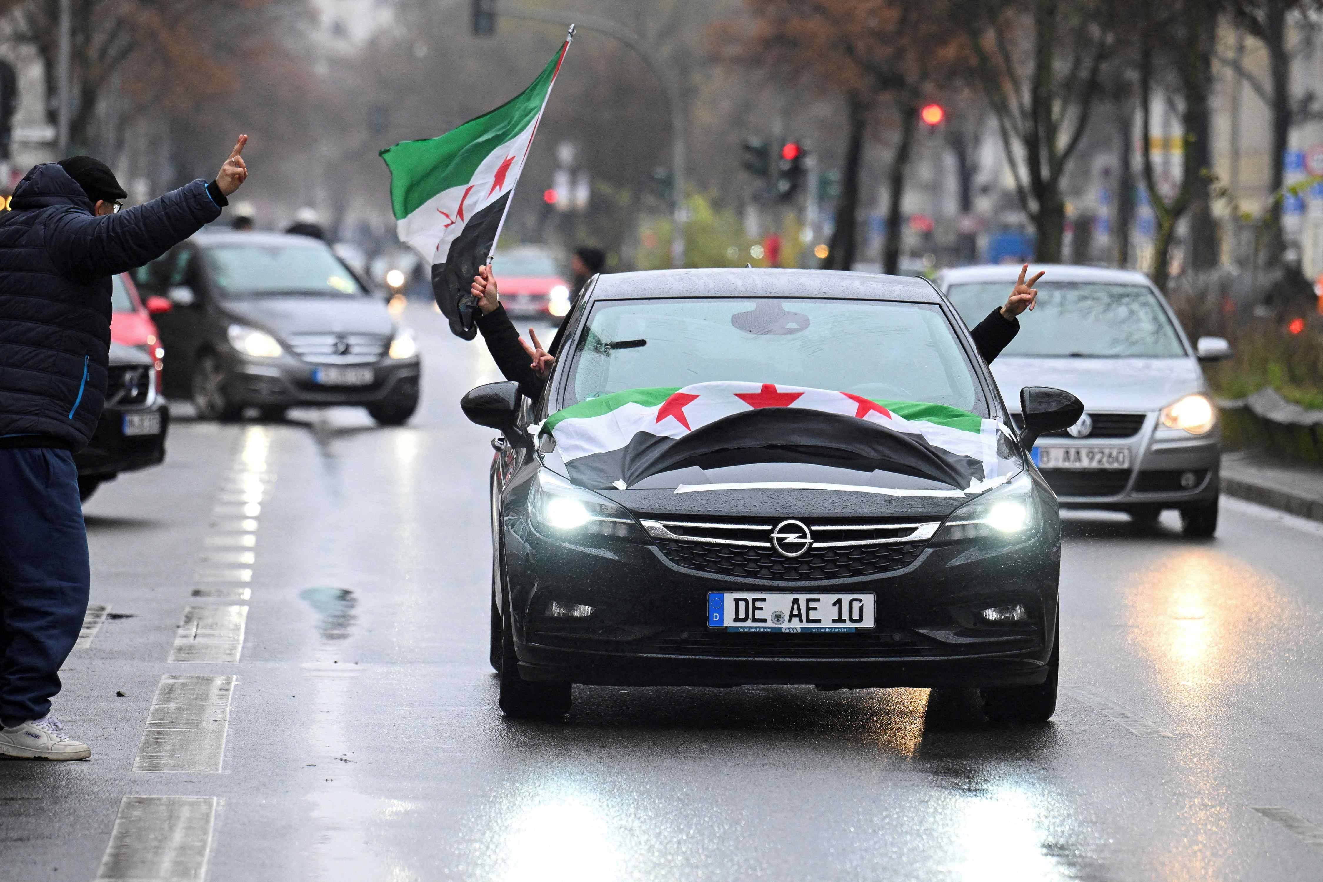 Pessoas passeiam de carro com bandeiras da oposição síria, em Berlim, Alemanha. REUTERS/Annegret Hilse
