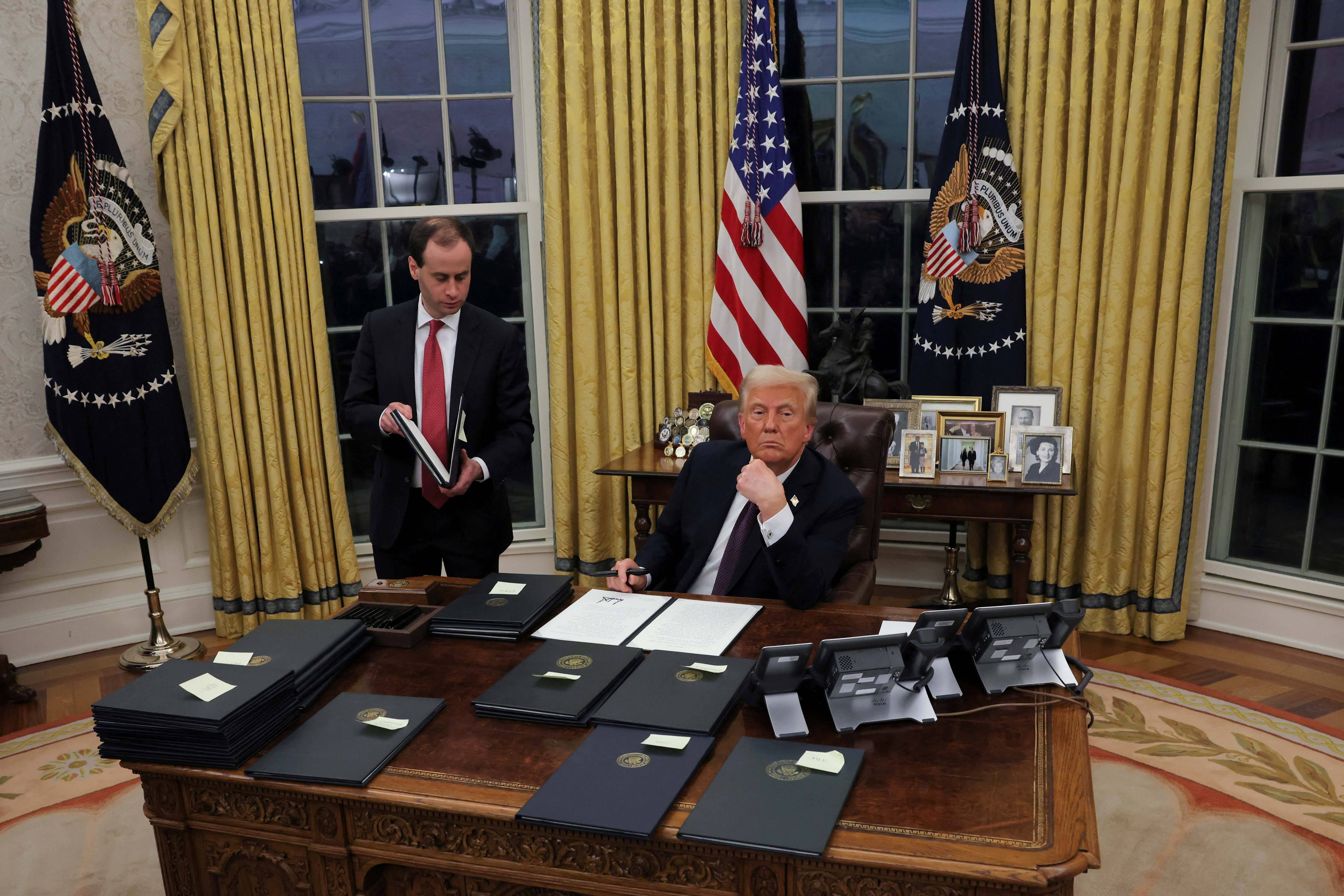 O presidente dos EUA, Donald Trump, assina ordens executivas para os réus de 6 de janeiro no Salão Oval da Casa Branca no Dia da Inauguração, em Washington, EUA, 20 de janeiro de 2025. REUTERS/Carlos Barria