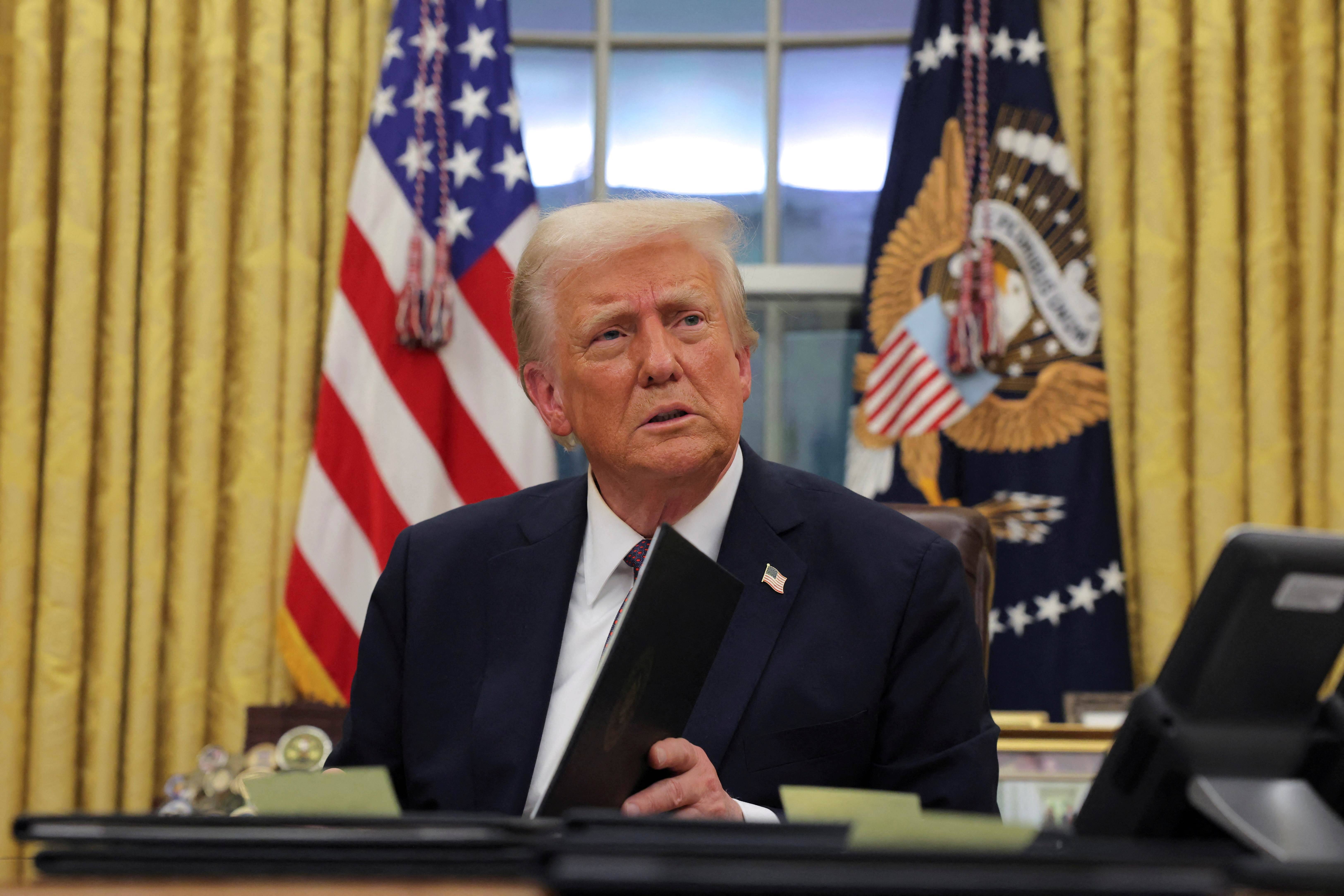 O presidente dos EUA, Donald Trump, assina ordens executivas para os réus de 6 de janeiro no Salão Oval da Casa Branca no Dia da Inauguração, em Washington, EUA, 20 de janeiro de 2025. REUTERS/Carlos Barria