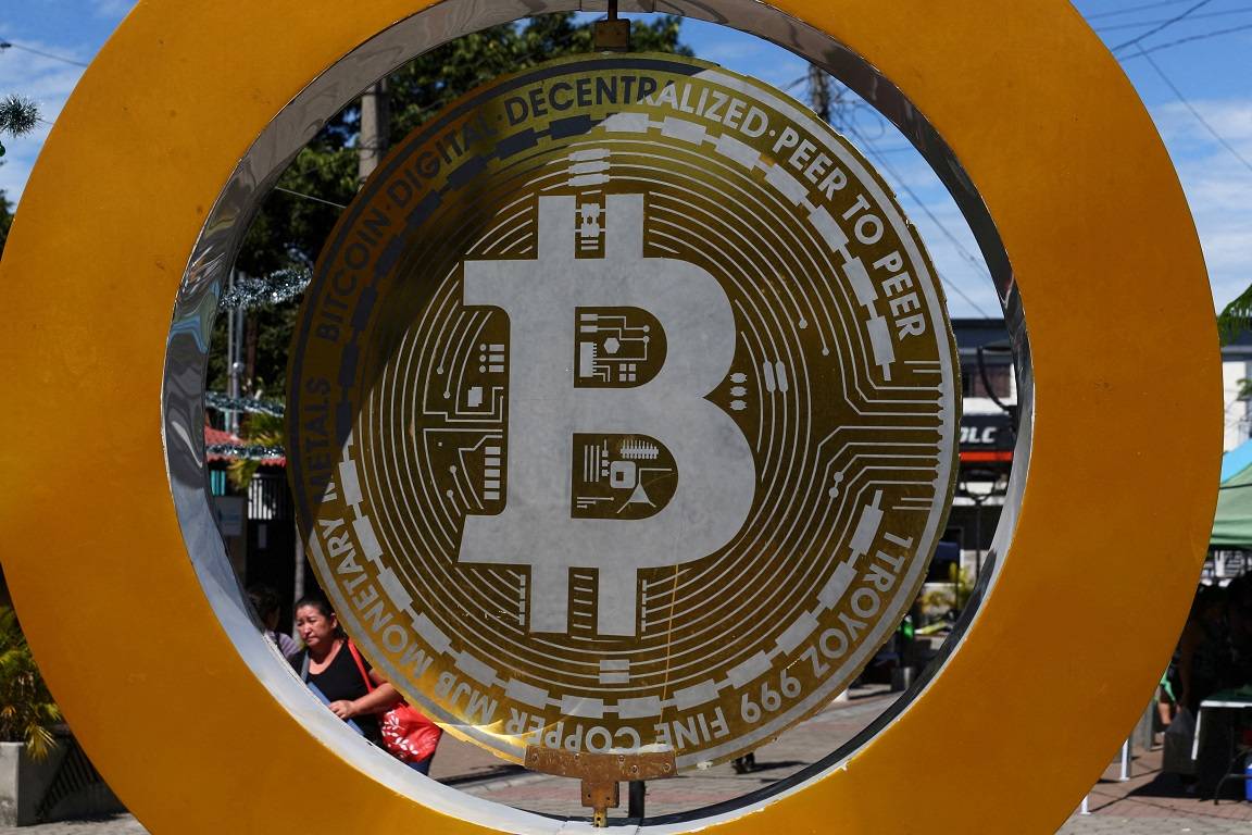 Uma mulher passa pelo Monumento ao Bitcoin em El Salvador - 05/12/2024 (Foto: REUTERS/Jose Cabezas)
