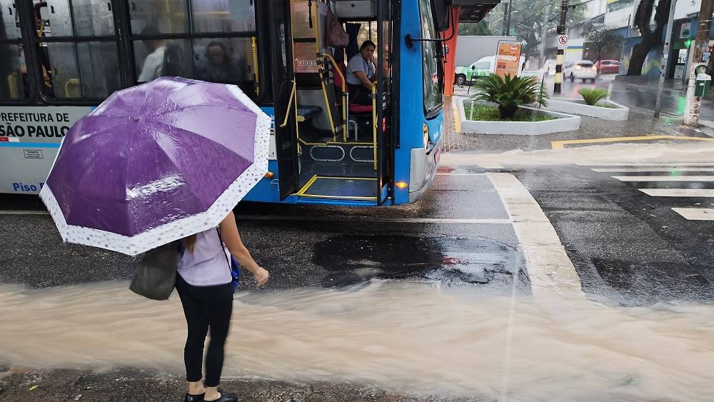 Passageira observa fluxo de água na rua antes de embarcar em ônibus no Itaim Bibi, na zona sul de São Paulo,   durante a forte chuva que atingiu a cidade no final da tarde desta quinta-feira, 16.    16/01/2025 - Foto: LEANDRO CHEMALLE/THENEWS2/ESTADÃO CONTEÚDO