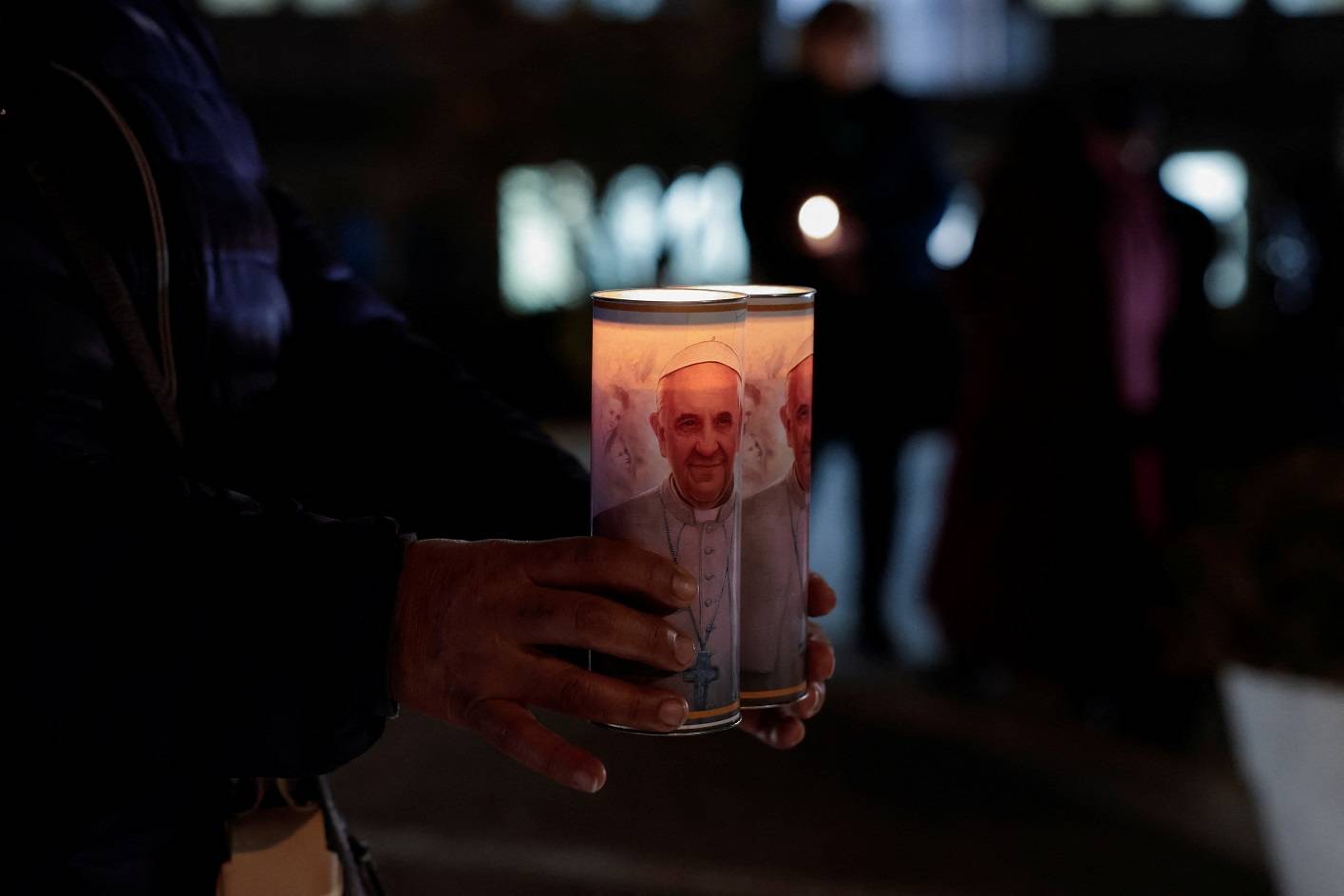 Um fiel da Bolívia segura velas acesas com o retrato do Papa Francisco do lado de fora do Hospital Gemelli, onde o papa está internado para continuar o tratamento de uma infecção respiratória, em Roma, Itália, 18 de fevereiro de 2025. REUTERS/Remo Casilli