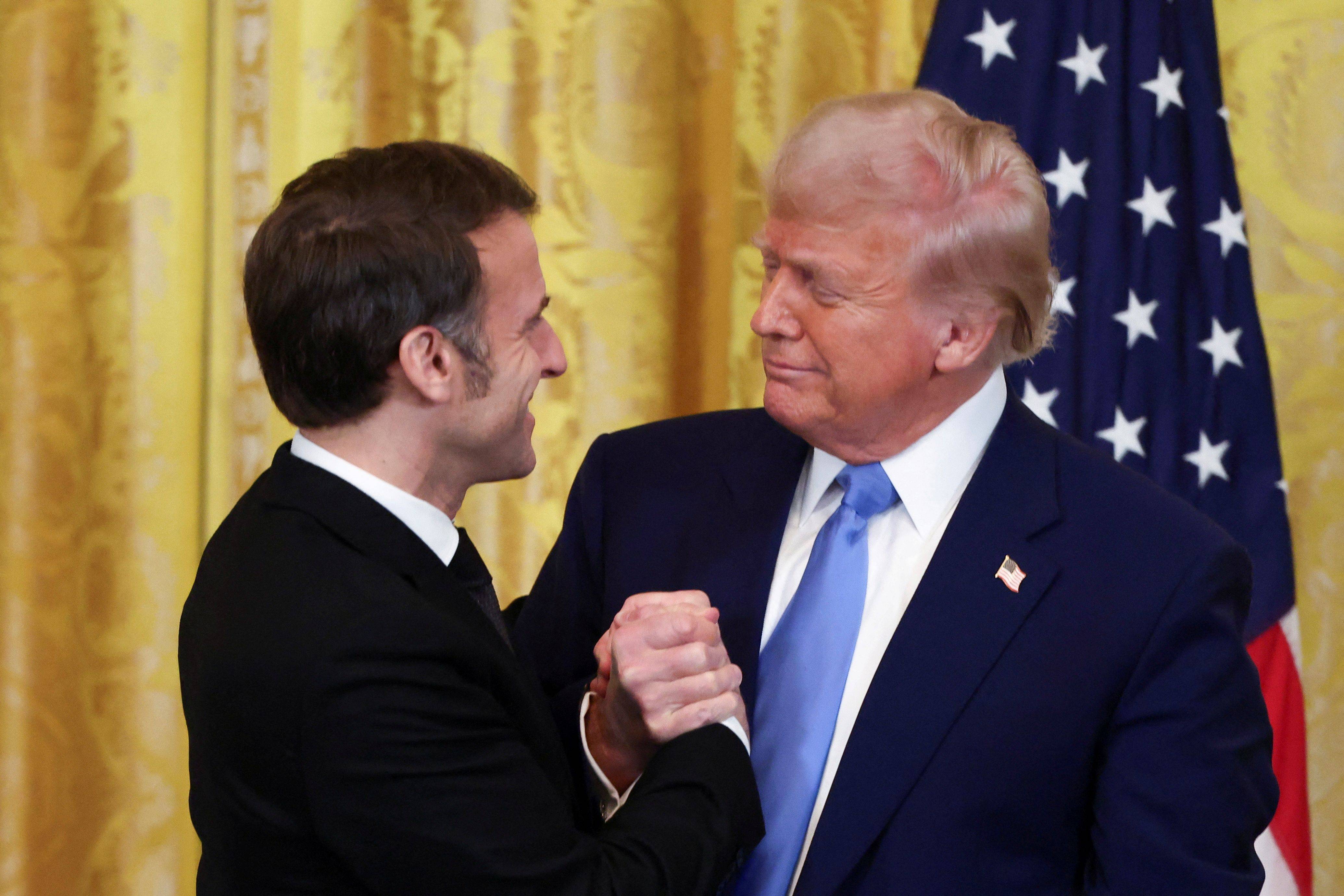 Trump e Macron se cumprimentam na Casa Branca 24/02/2025 REUTERS/Evelyn Hockstein


