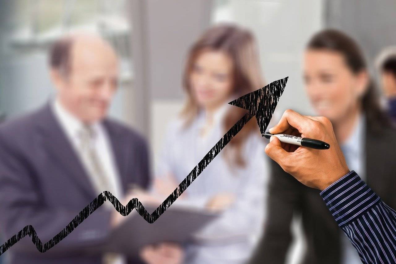 Imagem mostra gráfico e funcionários discutindo PLR