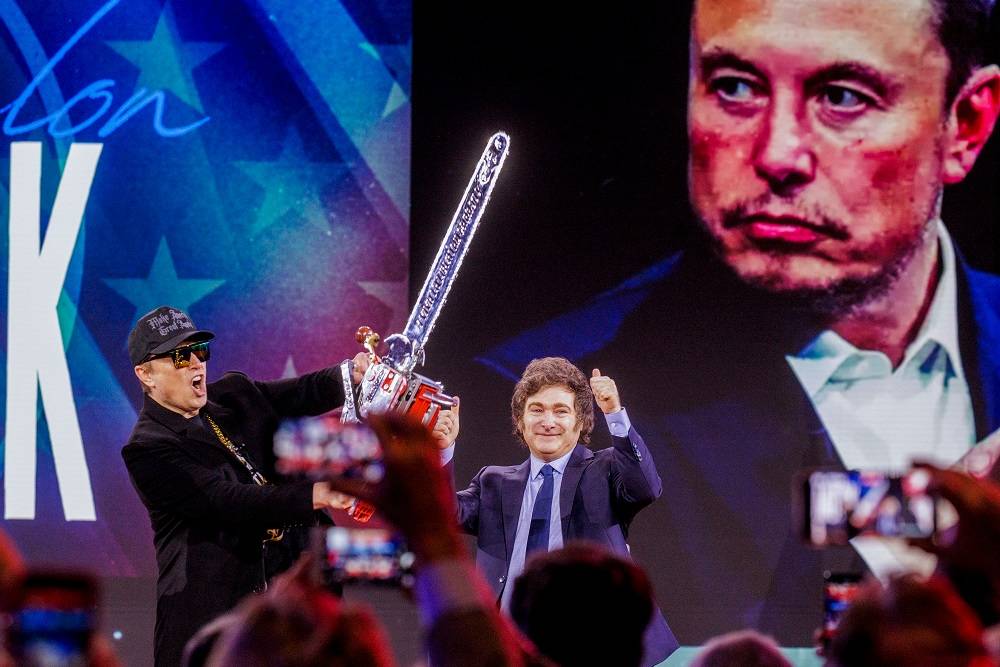 Elon Musk segura uma motosserra presenteada a ele por Javier Milei durante a Conferência de Ação Política Conservadora em National Harbor. Fotógrafo: Jason C. Andrew/Bloomberg