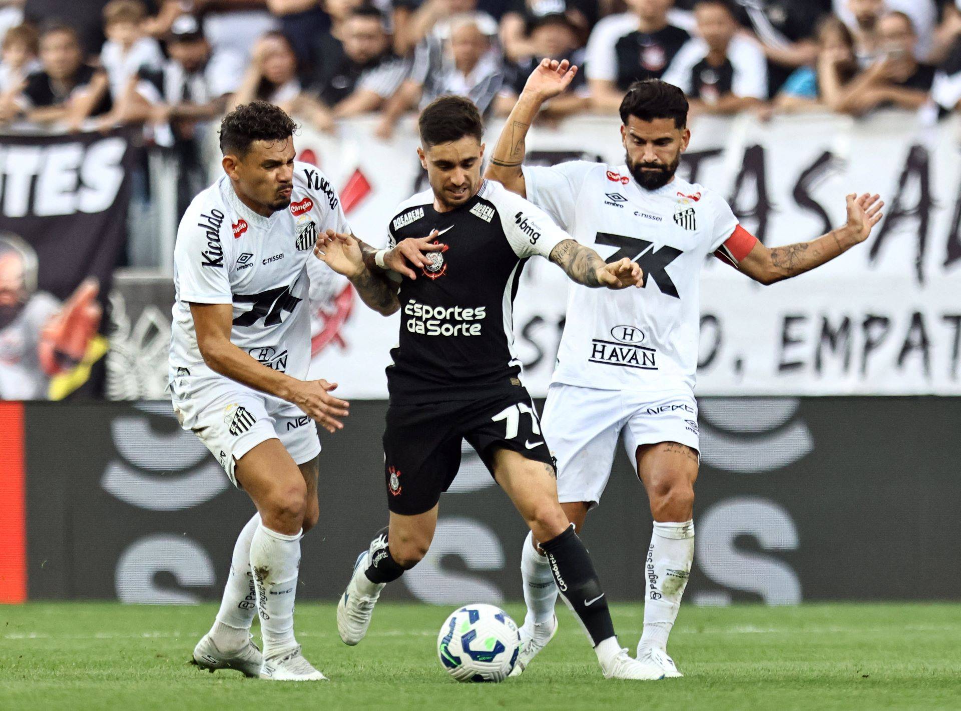 Tomas Rincon (esq.) e Tiquinho Soares (dir.) , do Santos, disputam jogada com Igor Coronado, do Corinthians, em partida do Campeonato Brasileiro - 18/05/2025 (Foto: REUTERS/Thiago Bernardes)