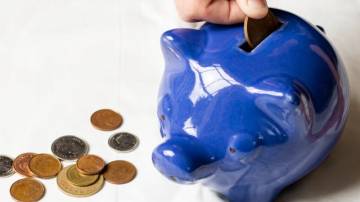 Como começar a investir em 2025 - Cofrinho azul com moedas