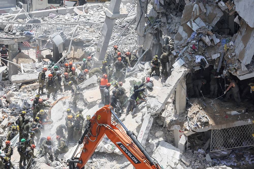 Equipes de resgate trabalham em um local atingido por um ataque de míssil do Irã, em Bat Yam, Israel, em 15 de junho de 2025. REUTERS/Ronen Zvulun TPX IMAGENS DO DIA