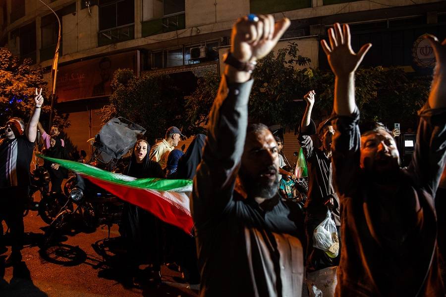 Pessoas acenam com bandeiras iranianas enquanto celebram o ataque do Irã a uma base militar dos EUA nas ruas de Teerã, Irã, na segunda-feira, 23 de junho de 2025 (Arash Khamooshi/The New York Times)

