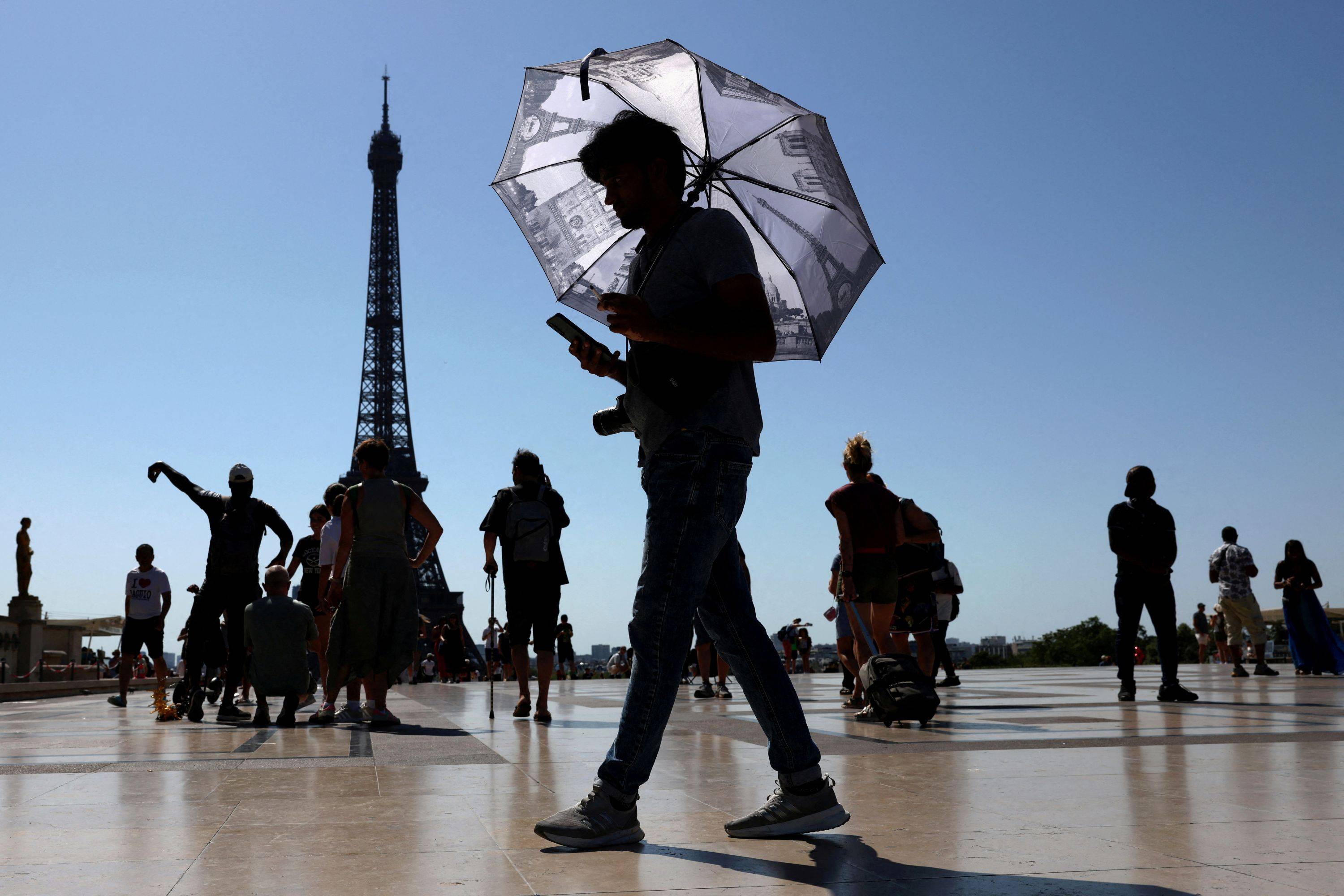 Turista se protege do calor em Paris 1/7/2025 REUTERS/Tom Nicholson