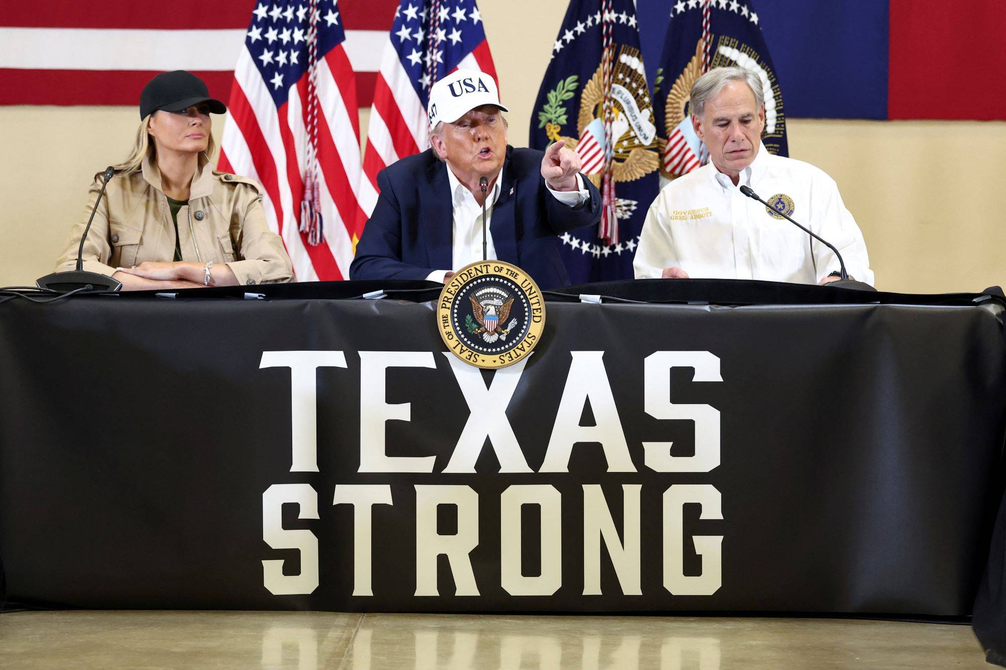 O presidente dos EUA, Donald Trump, a primeira-dama Melania Trump e o governador do Texas, Greg Abbott, participam de uma mesa-redonda com socorristas e autoridades locais, no Hill Country Youth Center, em Kerrville, Texas, EUA, 11 de julho de 2025. (Foto: Kevin Lamarque/Reuters)