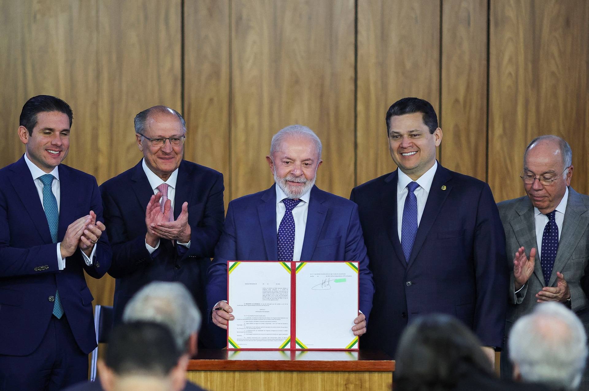 O presidente Luiz Inácio Lula da Silva, o vice-presidente Geraldo Alckmin, o presidente da Câmara dos Deputados Hugo Motta, o presidente do Senado Federal Davi Alcolumbre e outras autoridades participam de uma cerimônia para assinar uma medida provisória que estabelece um conjunto inicial de ações para mitigar o impacto econômico devido à decisão do presidente dos EUA, Donald Trump, de aumentar as tarifas de importação de produtos brasileiros em até 50%, no Palácio do Planalto, em Brasília, Brasil, 13 de agosto de 2025. REUTERS/Adriano Machado
