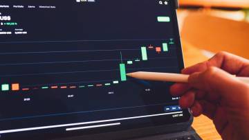 A imagem mostra um assessor de investimentos acompanhando um gráfico de ativo financeiro; imagem pública de banco de imagens.