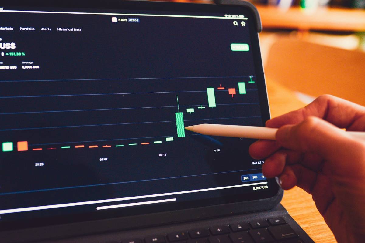 A imagem mostra um assessor de investimentos acompanhando um gráfico de ativo financeiro; imagem pública de banco de imagens.