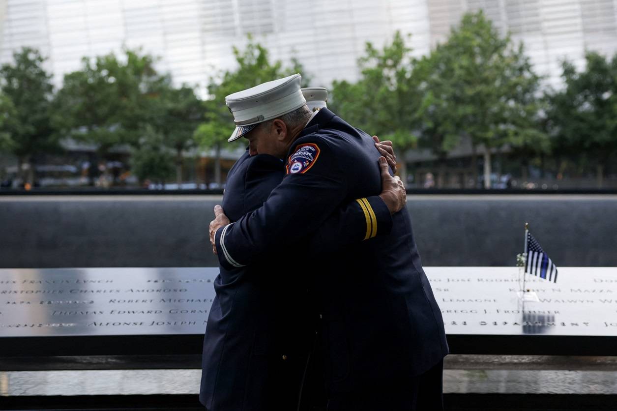 Oficiais se abraçam antes da cerimônia que marca o 24º aniversário dos ataques de 11 de setembro de 2001 ao World Trade Center, no Memorial e Museu do 11 de Setembro, no bairro de Manhattan, na cidade de Nova York, EUA, 11 de setembro de 2025. REUTERS/Jeenah Moon


