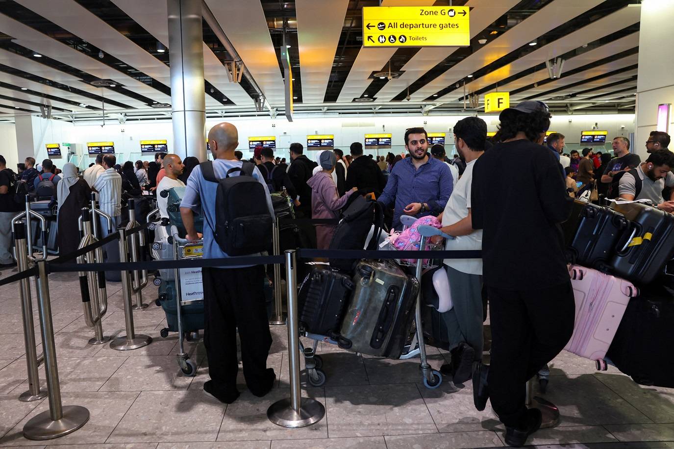 Viajantes fazem fila para fazer check-in no Terminal 4 do Aeroporto de Heathrow, após uma interrupção nos sistemas de check-in e embarque causada por um ataque cibernético que afetou vários grandes aeroportos europeus, resultando em atrasos e cancelamentos de voos, na Grande Londres, Reino Unido, 20 de setembro de 2025. REUTERS/Isabel Infantes/FOTO DE ARQUIVO