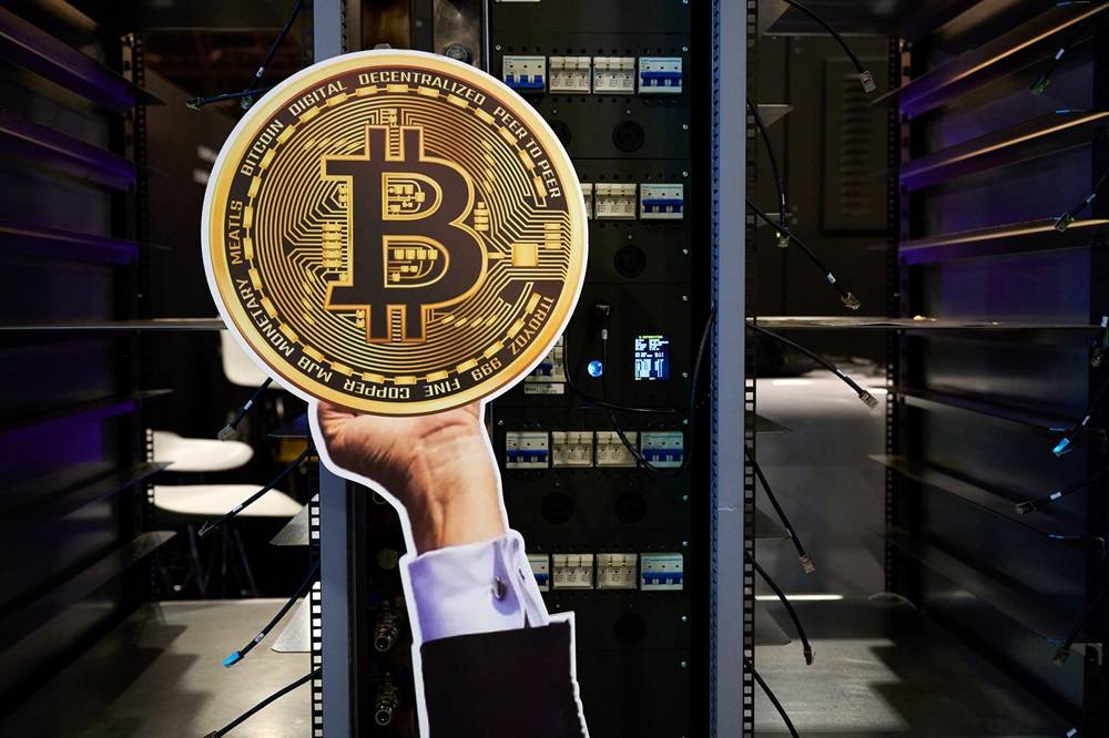 Recorte de um token de Bitcoin no estande da Moonshots durante a conferência Bitcoin 2025 em Las Vegas, Nevada, EUA, na terça-feira, 27 de maio de 2025. O evento discutirá o impacto global em evolução do Bitcoin, com palestrantes das áreas de educação, política, finanças e tecnologia. Fotógrafa: Bridget Bennett/Bloomberg