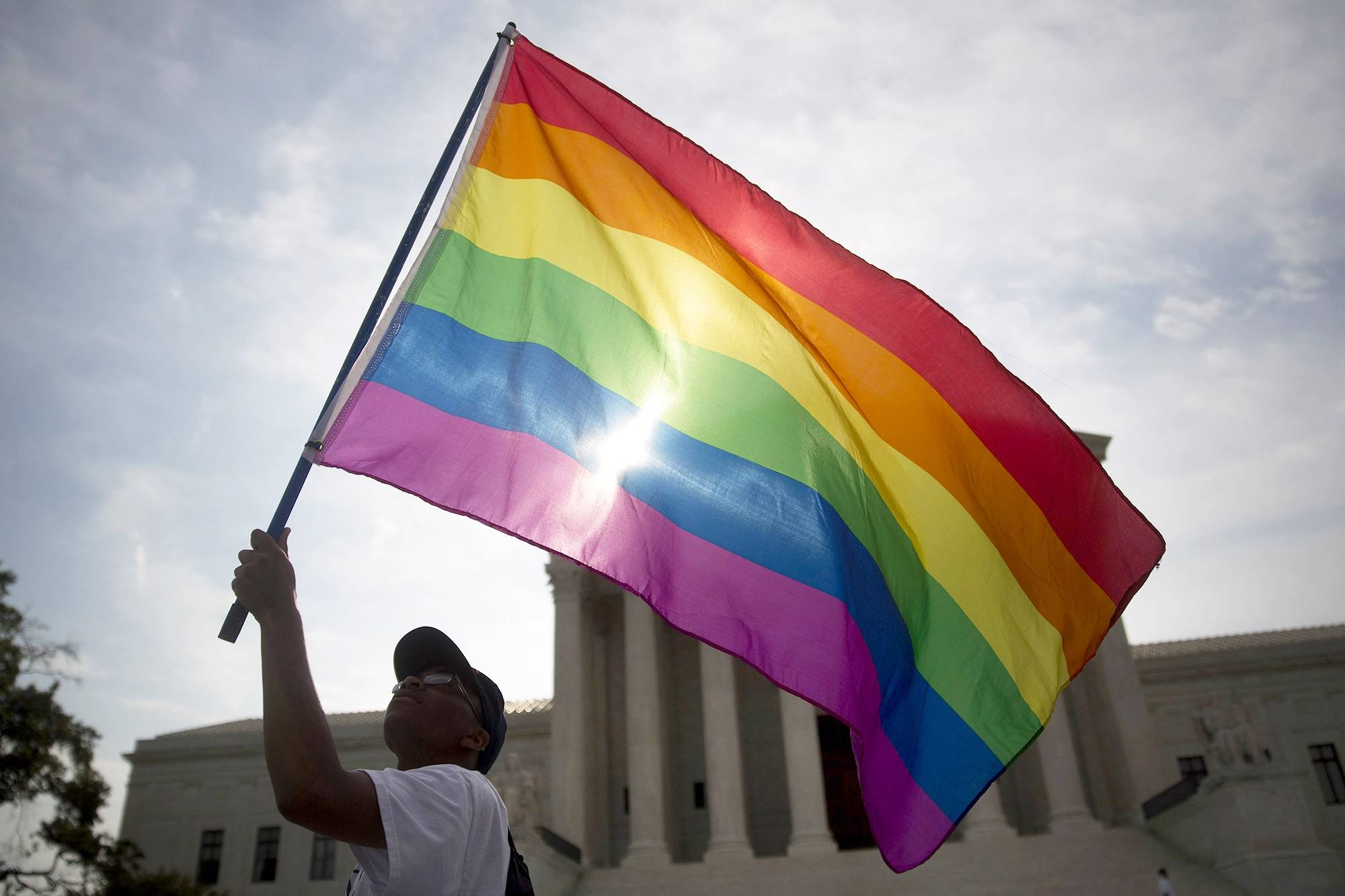 Um manifestante acena com uma bandeira do arco-íris em frente à Suprema Corte dos EUA em Washington (Andrew Harrer/Bloomberg)
