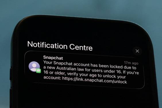 Uma notificação do Snapchat solicitando verificação de idade é exibida em um telefone celular, enquanto uma lei que proíbe redes sociais para usuários com menos de 16 anos na Austrália entra em vigor, nesta ilustração tirada em 9 de dezembro de 2025. REUTERS/Hollie Adams/Ilustração